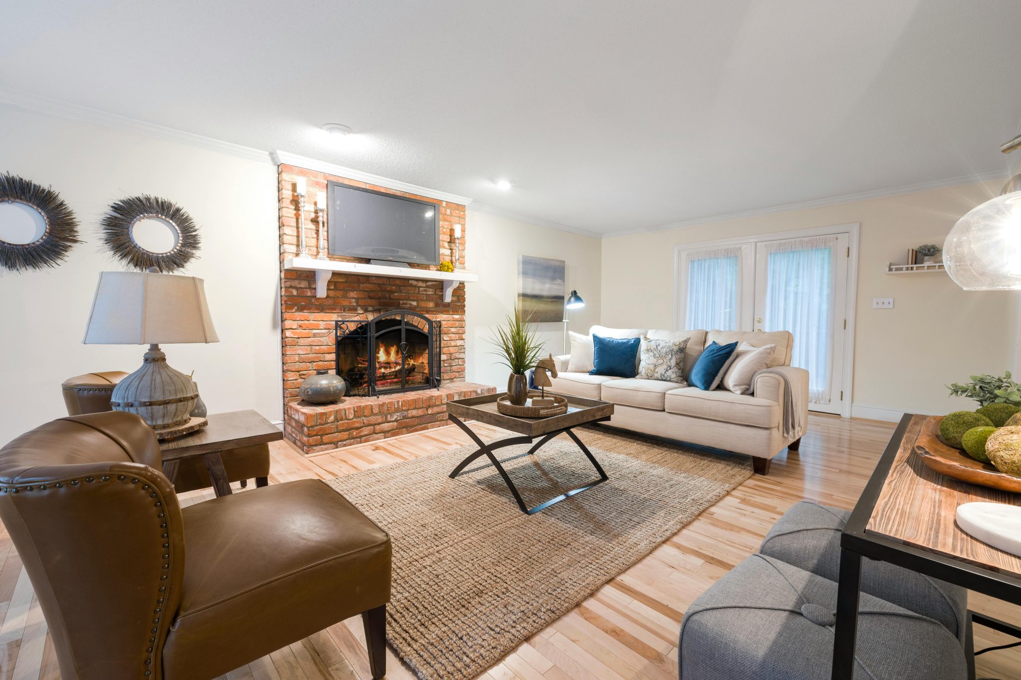 Inviting living room featuring cozy seating, brick fireplace, and stylish decor.