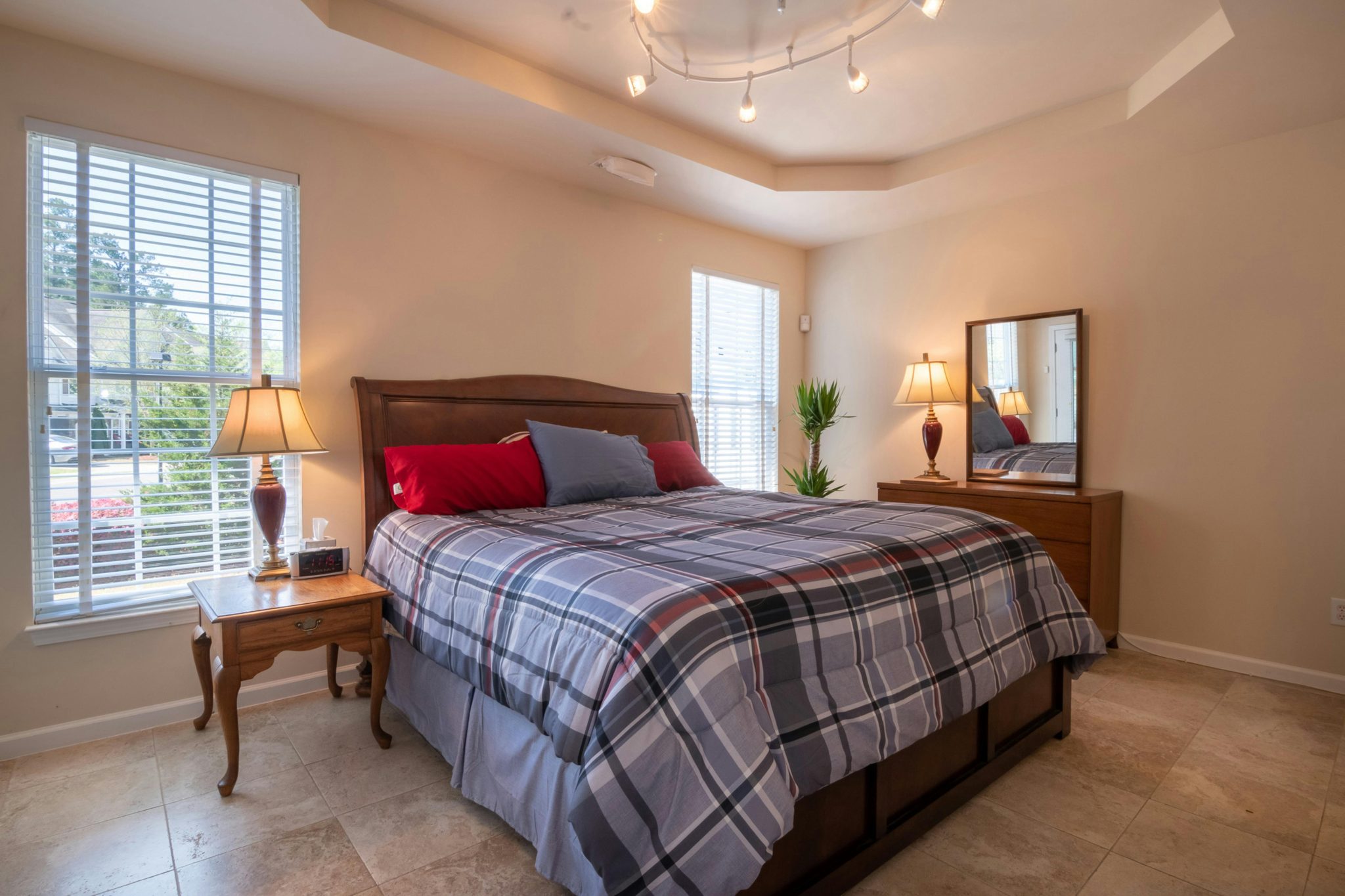 Inviting modern bedroom with plaid bedding and elegant furniture, perfect for relaxation.