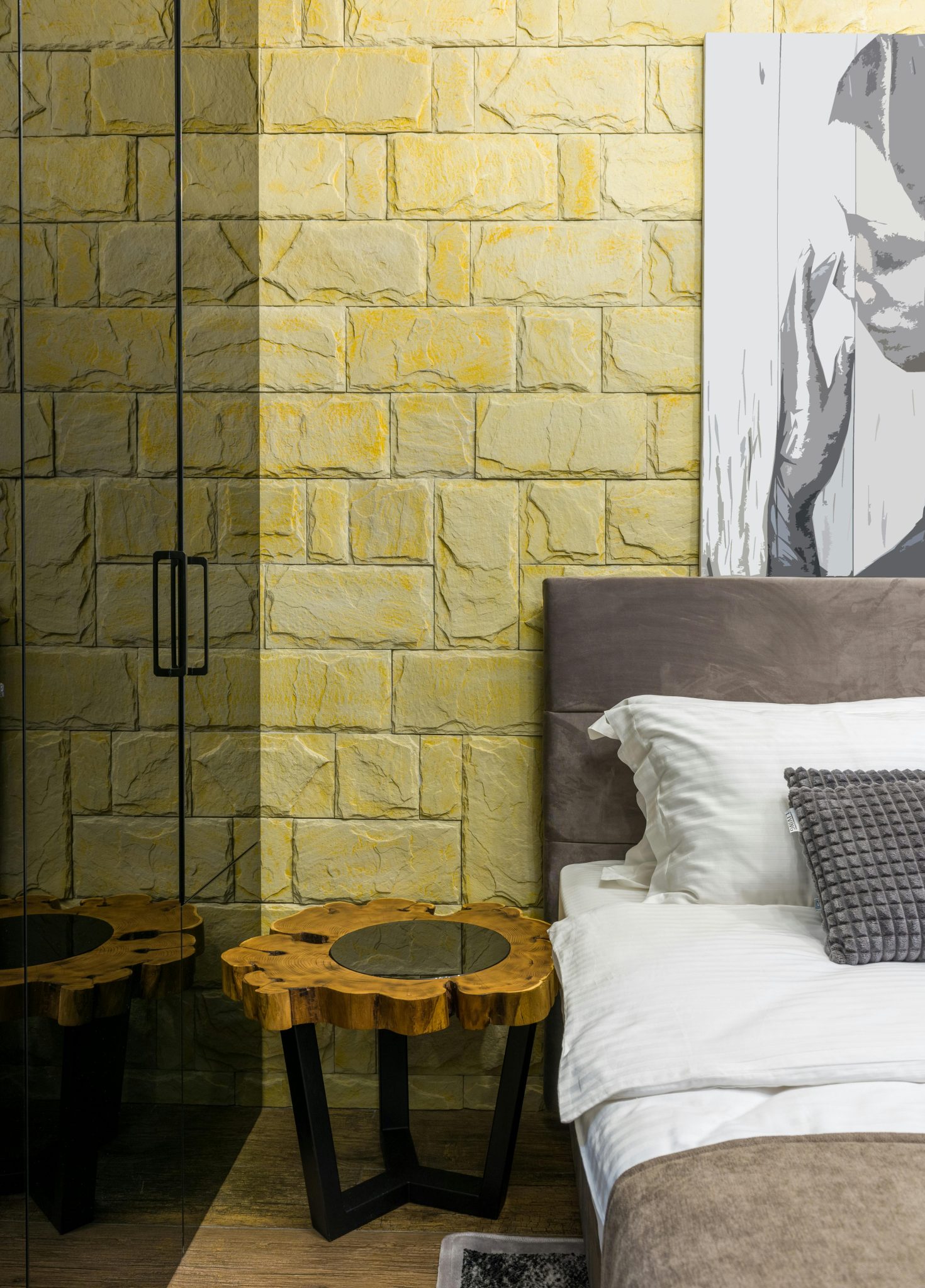 Loft style bedroom with soft pillows on blanket near decorative table on floor at home