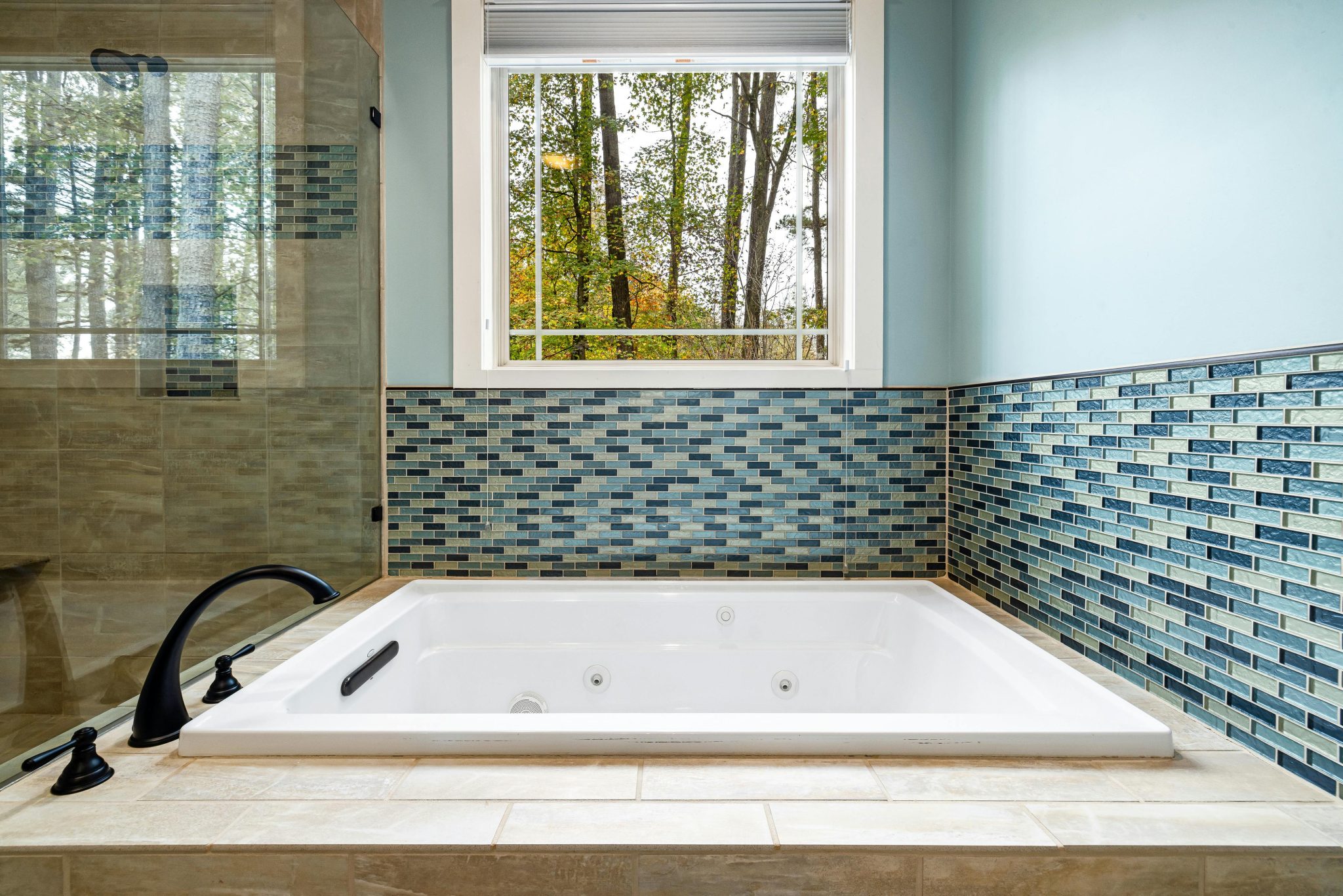 Luxurious modern bathroom featuring a jacuzzi tub and stylish tile design.