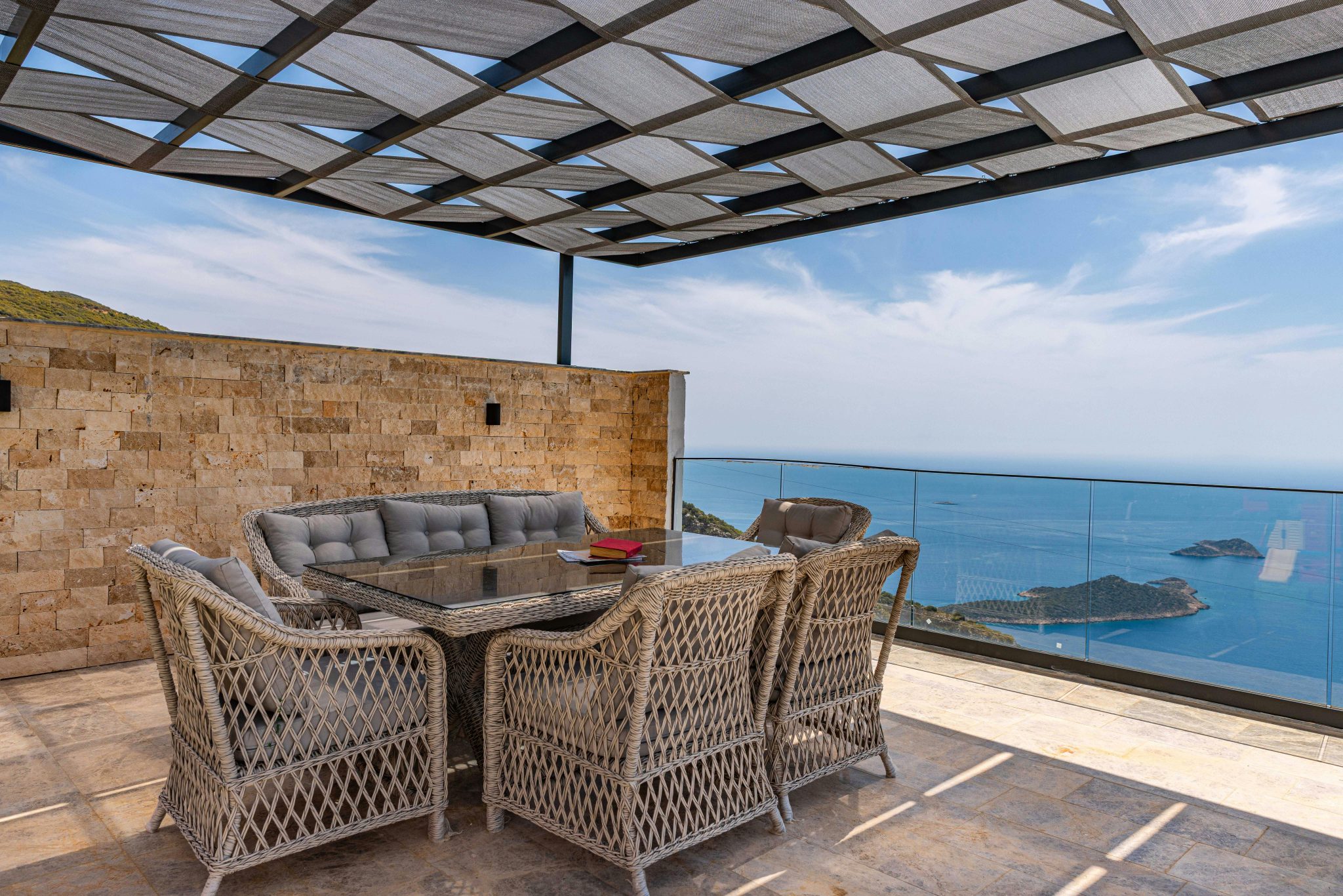 Luxury outdoor terrace with wicker furniture and ocean view.
