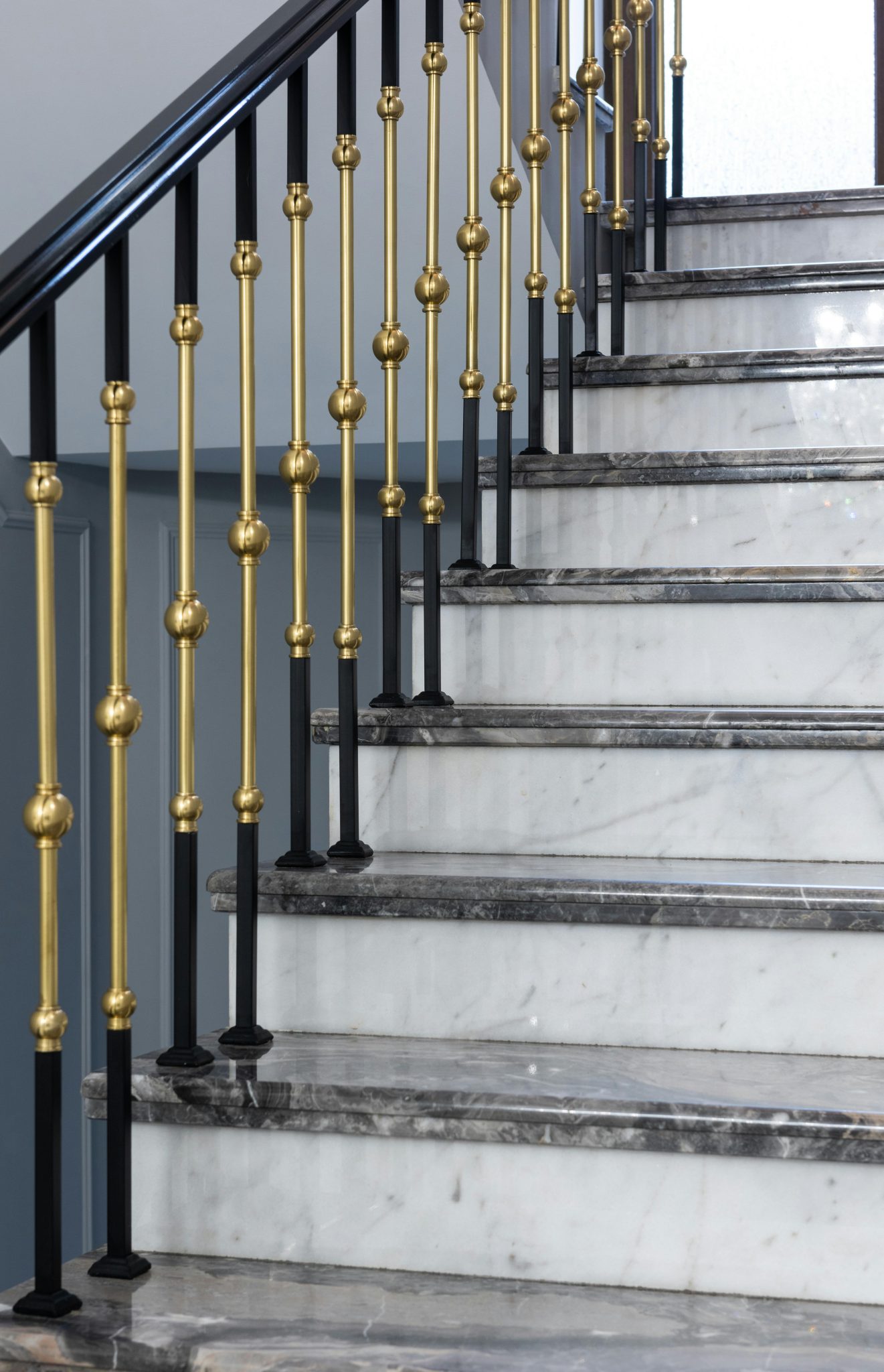 Marble steps of classic styled stairway with metal golden banister in villa in daytime