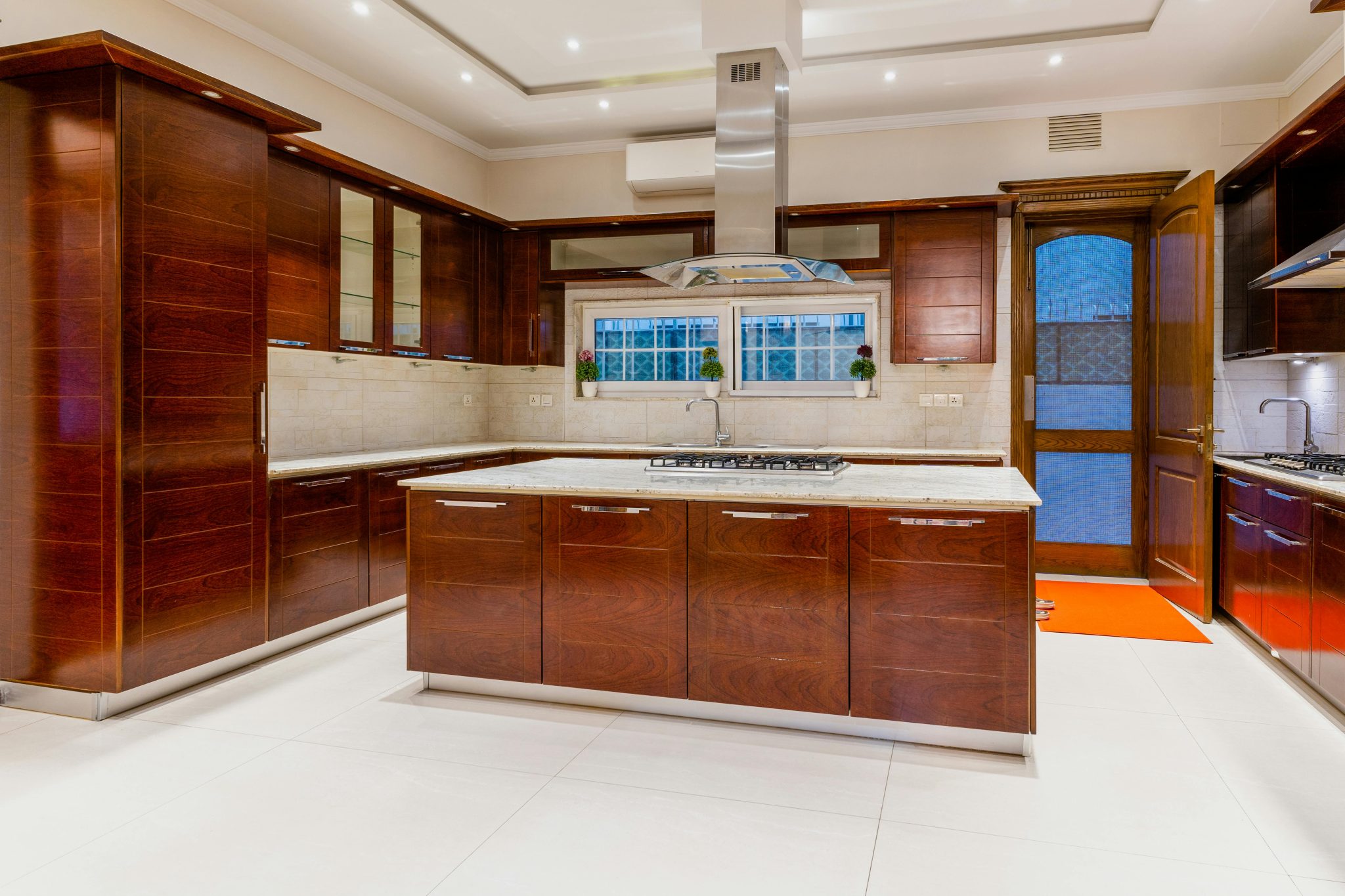 Modern kitchen with dark wood cabinets and marble countertops, emphasizing elegant interior design.