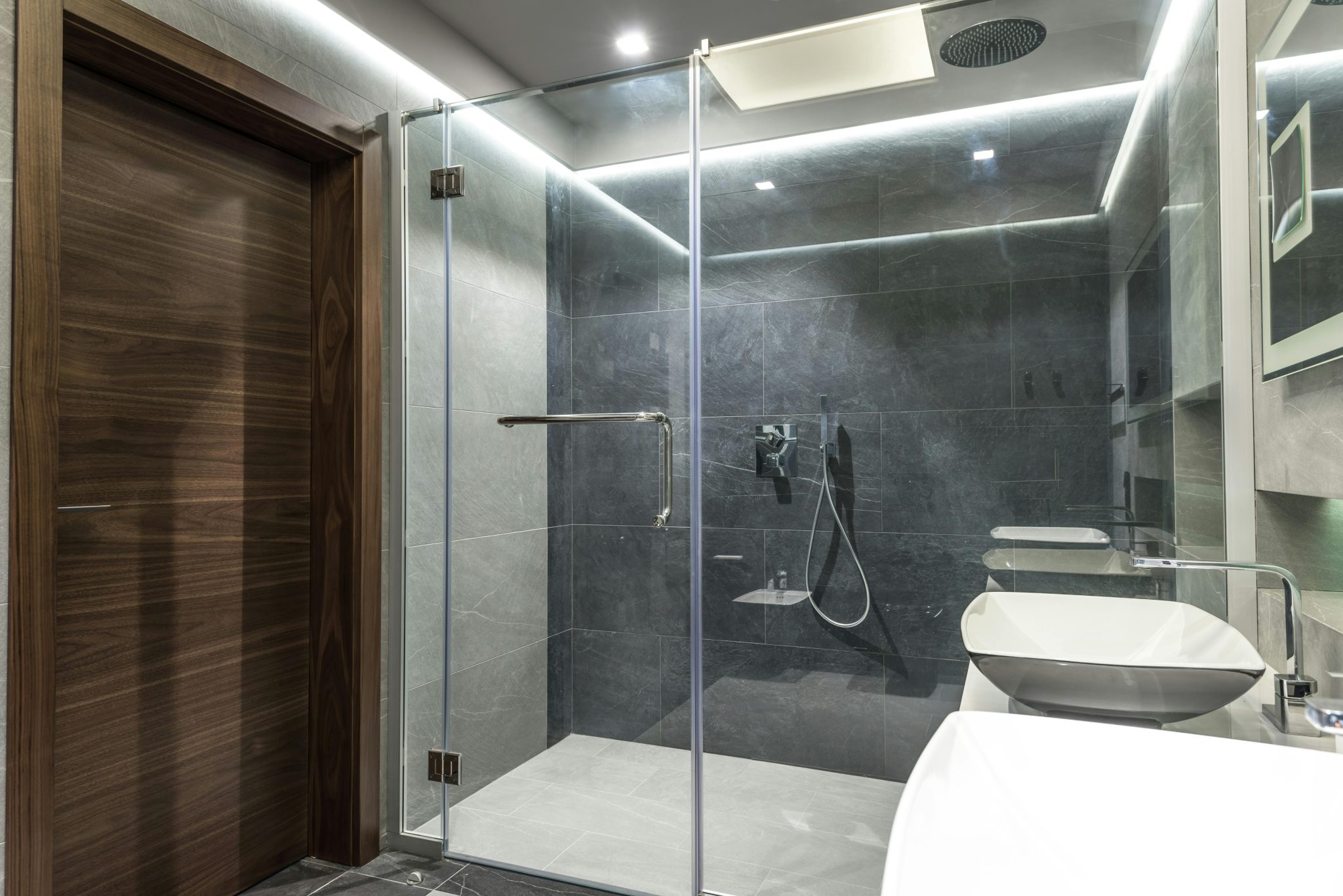 Modern minimalist bathroom featuring a spacious glass shower and sleek interior design.