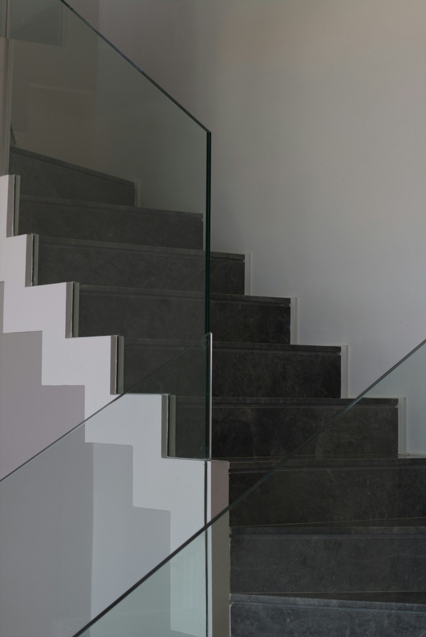 Modern staircase with glass railing and stone