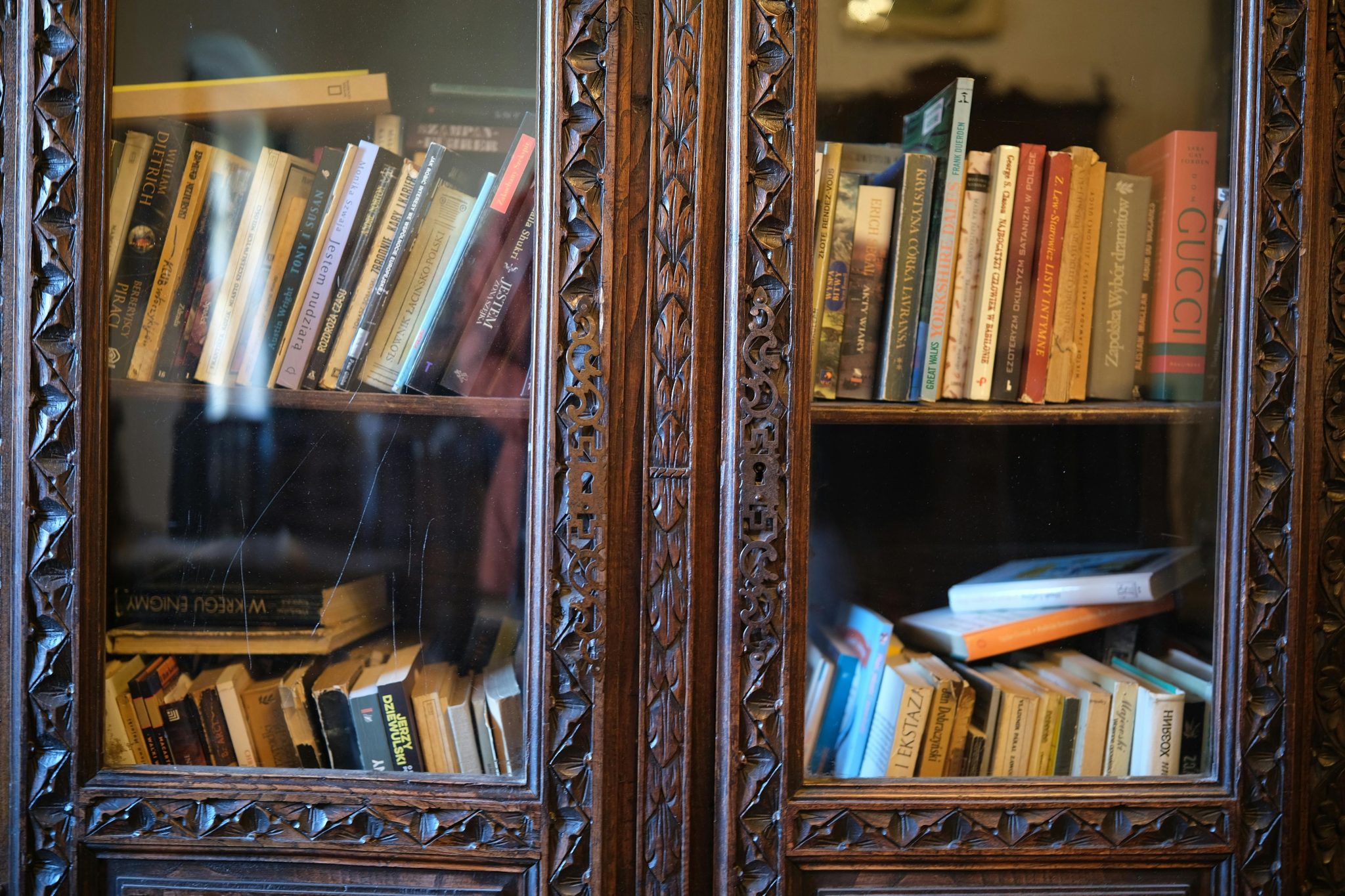 Ornately carved wooden bookshelf filled with assorted books, creating an inviting literary atmosphere.