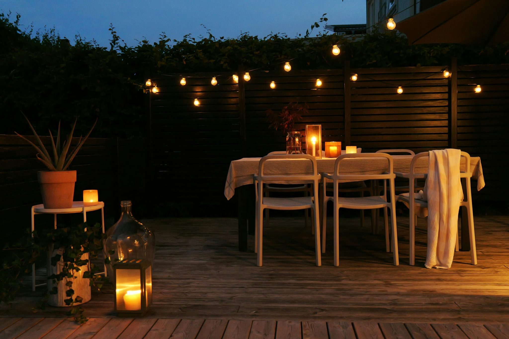 Outdoor dining setup with candles and string lights creates a cozy ambiance in Stockholm.