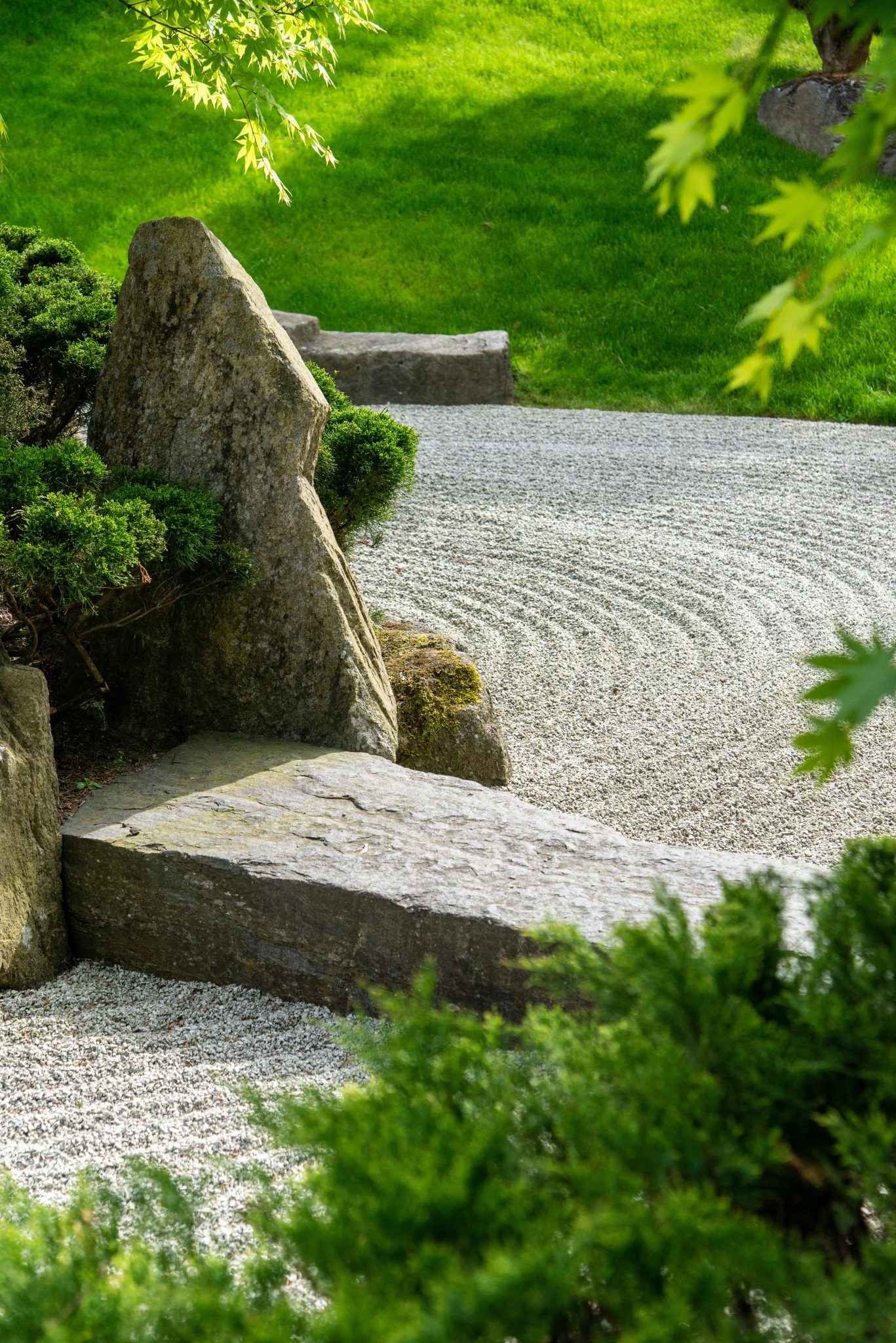 Serene Zen garden featuring a stone path and lush green foliage, ideal for meditation.