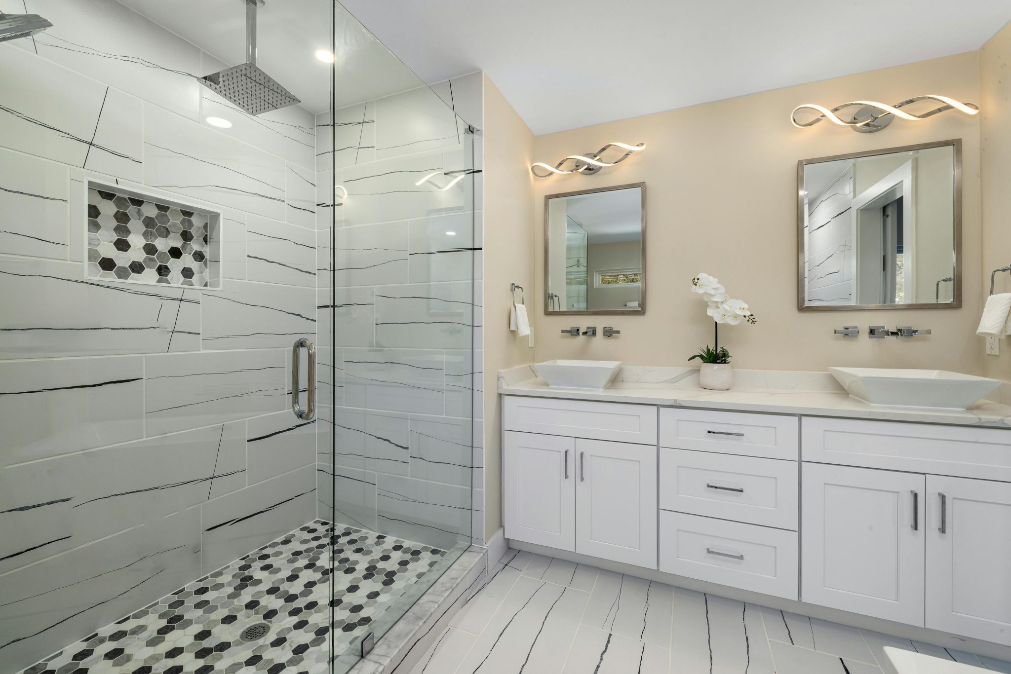 Sleek contemporary bathroom interior featuring a glass shower and double vanity with mirrors.