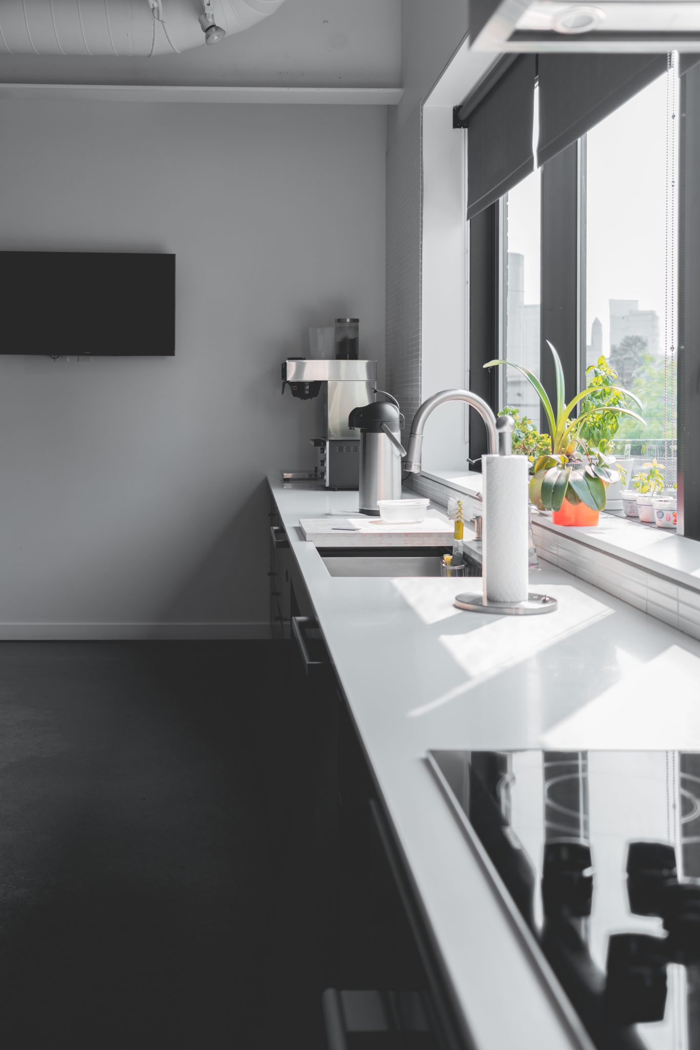 Sleek modern kitchen design featuring a sunlit countertop and large windows for a bright interior.