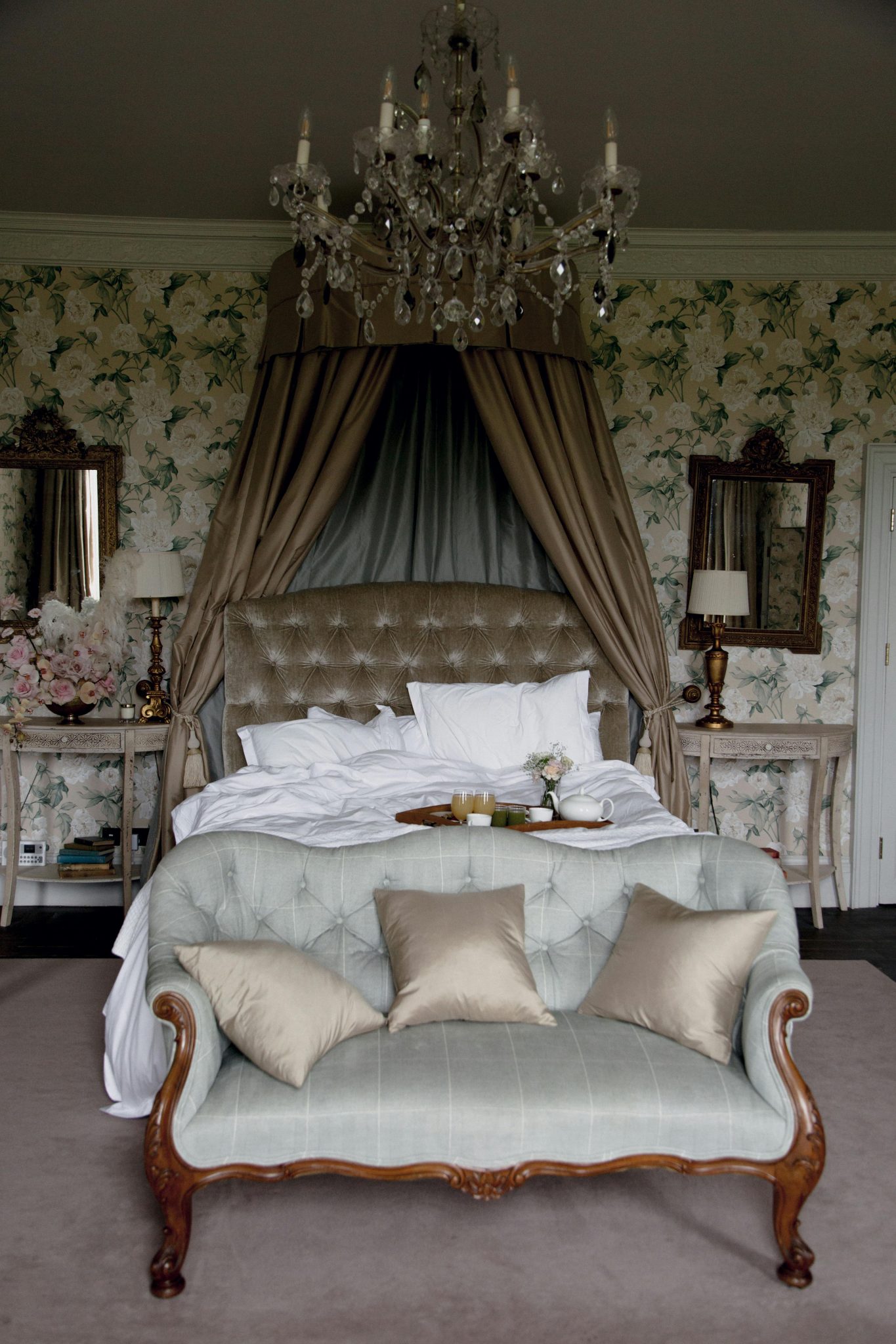 Sophisticated bedroom featuring vintage decor, elegant chandelier, and plush furnishings.