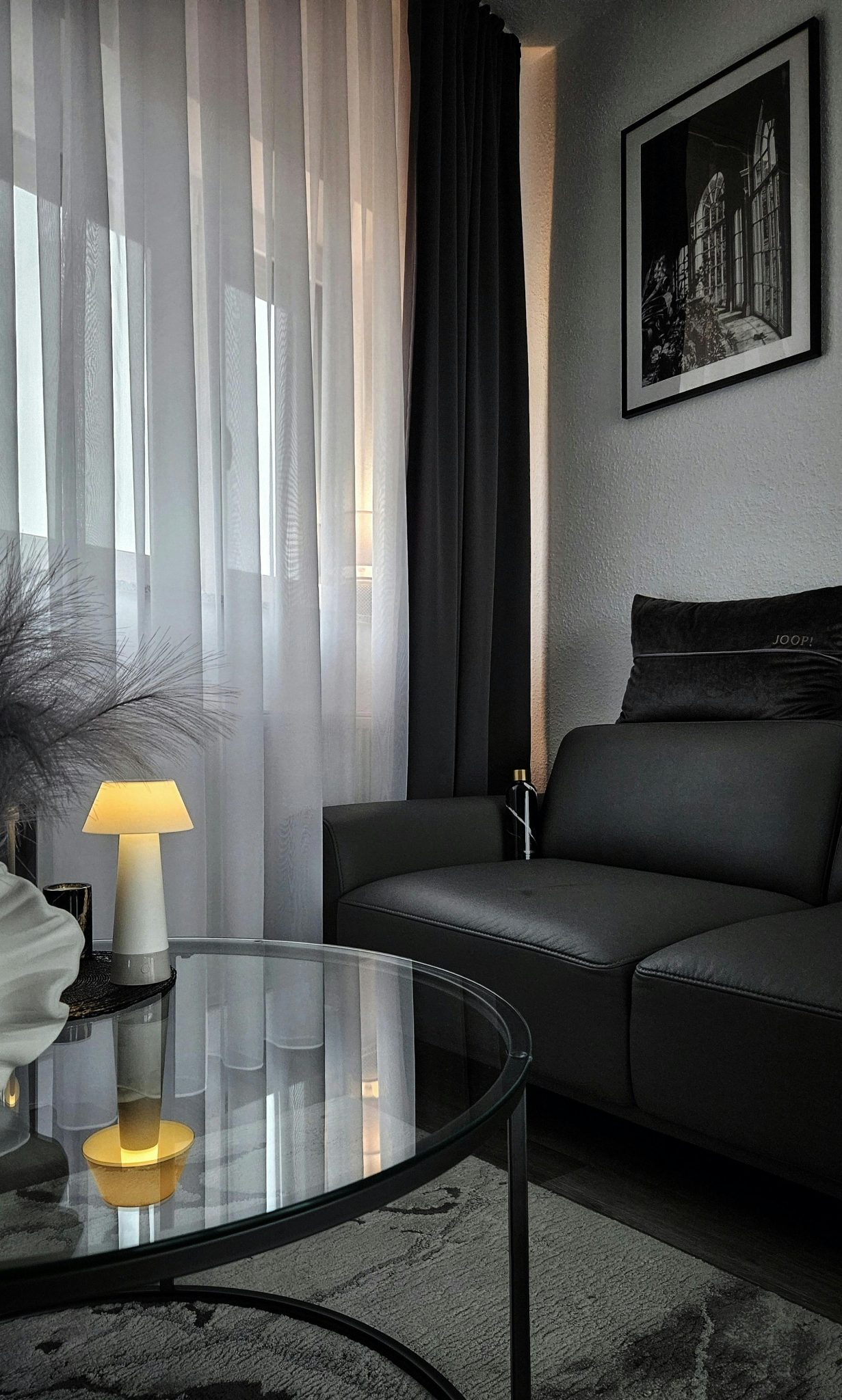 Sophisticated living room with dark aesthetic and modern furnishings, offering a cozy atmosphere.