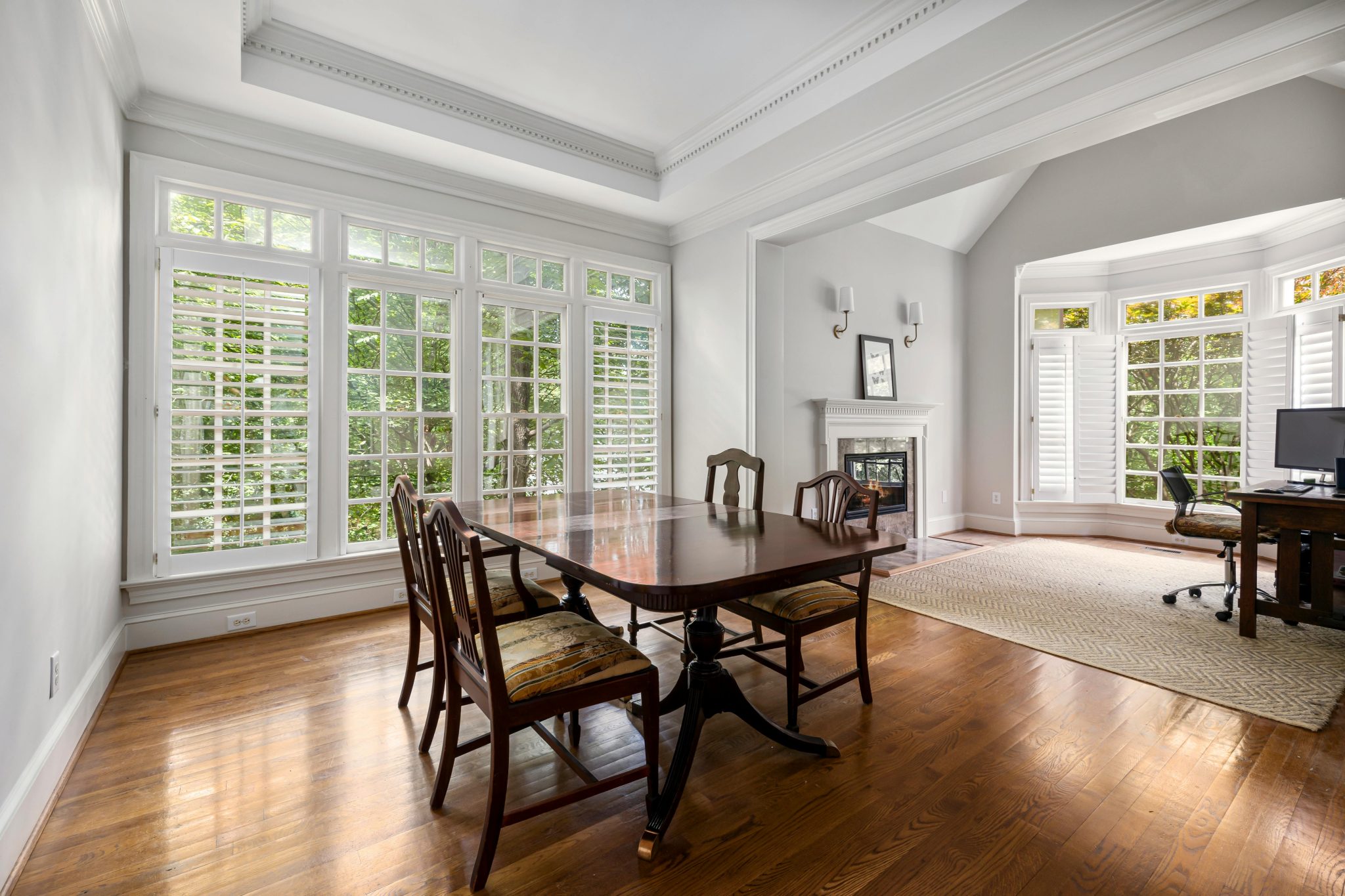 Spacious dining area with wooden furniture and large windows bringing in natural light.