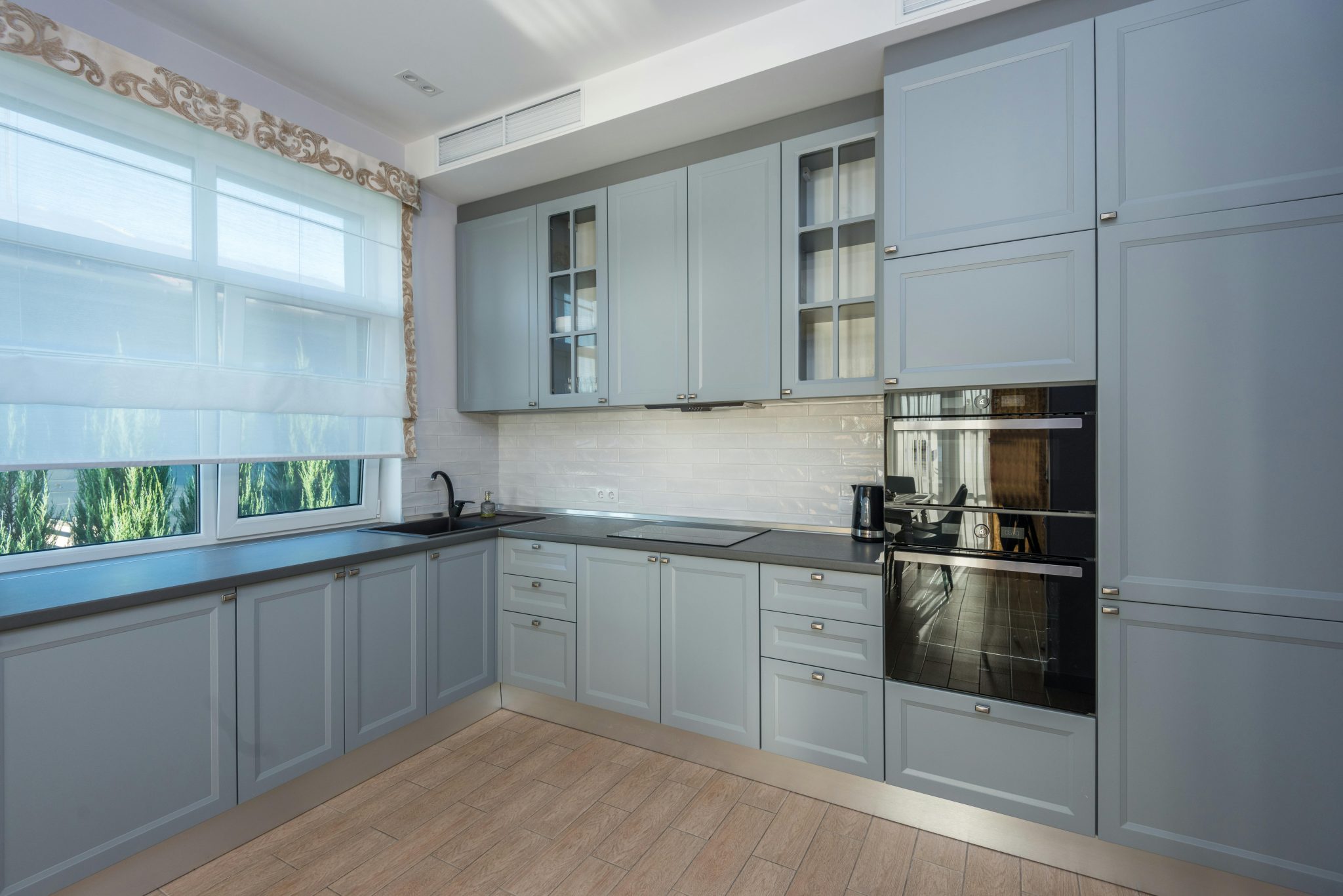 Spacious kitchen with modern cabinetry and large windows for ample natural light.