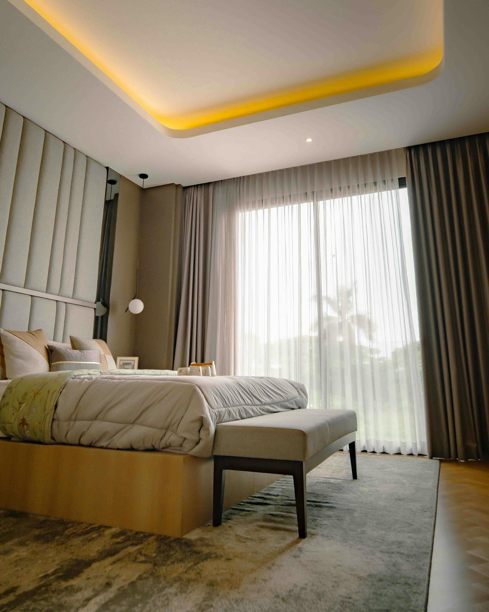 Spacious modern bedroom with elegant decor and natural lighting in Jakarta, Indonesia.