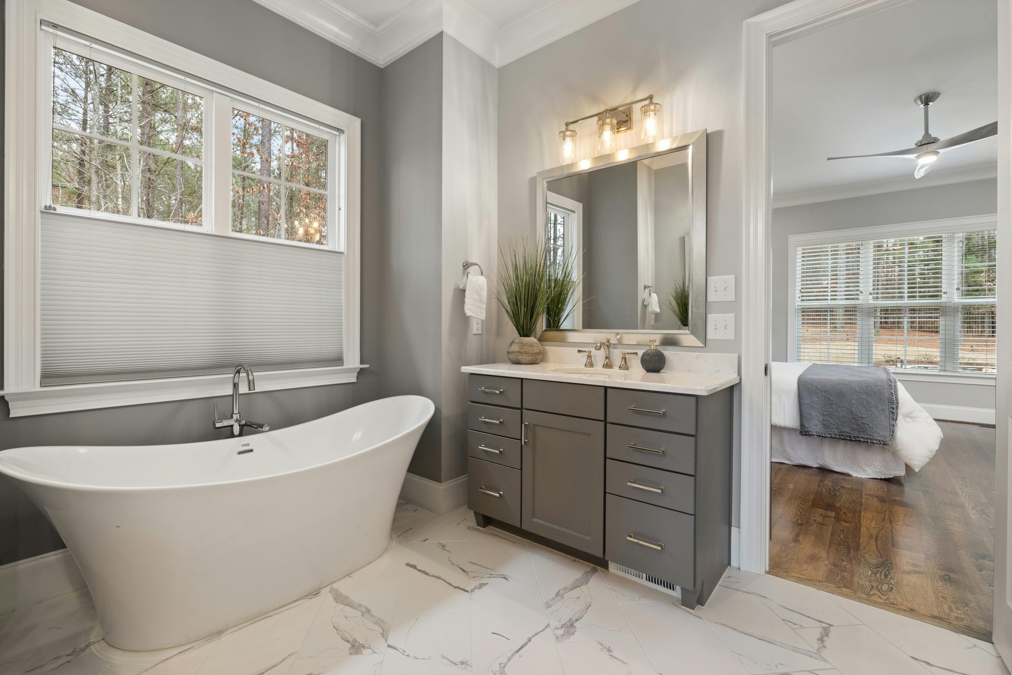 Stylish bathroom with freestanding tub and sleek vanity offers a modern, serene retreat.