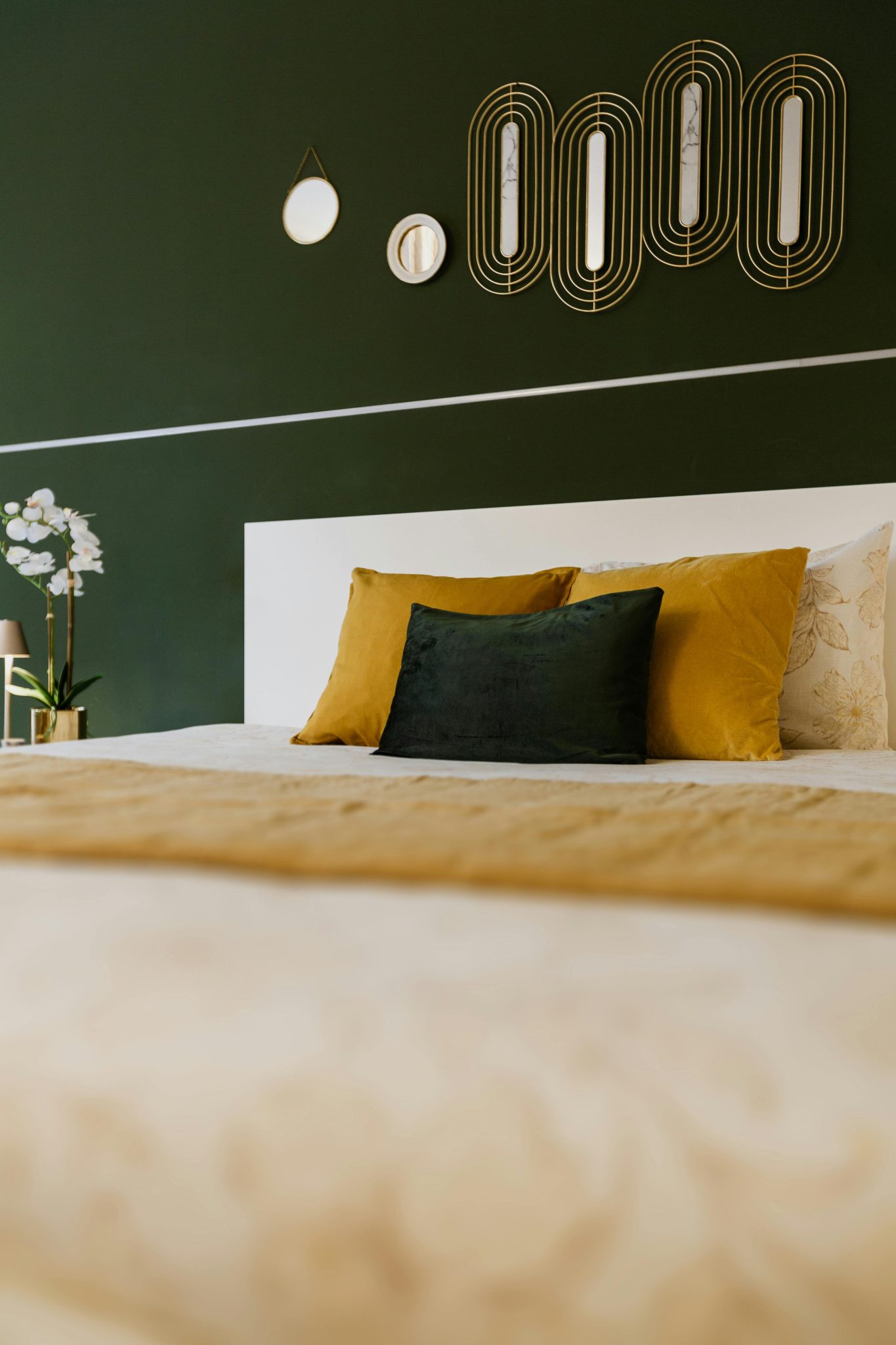 Stylish bedroom with modern decor featuring green and mustard tones, perfect for interior design inspiration.