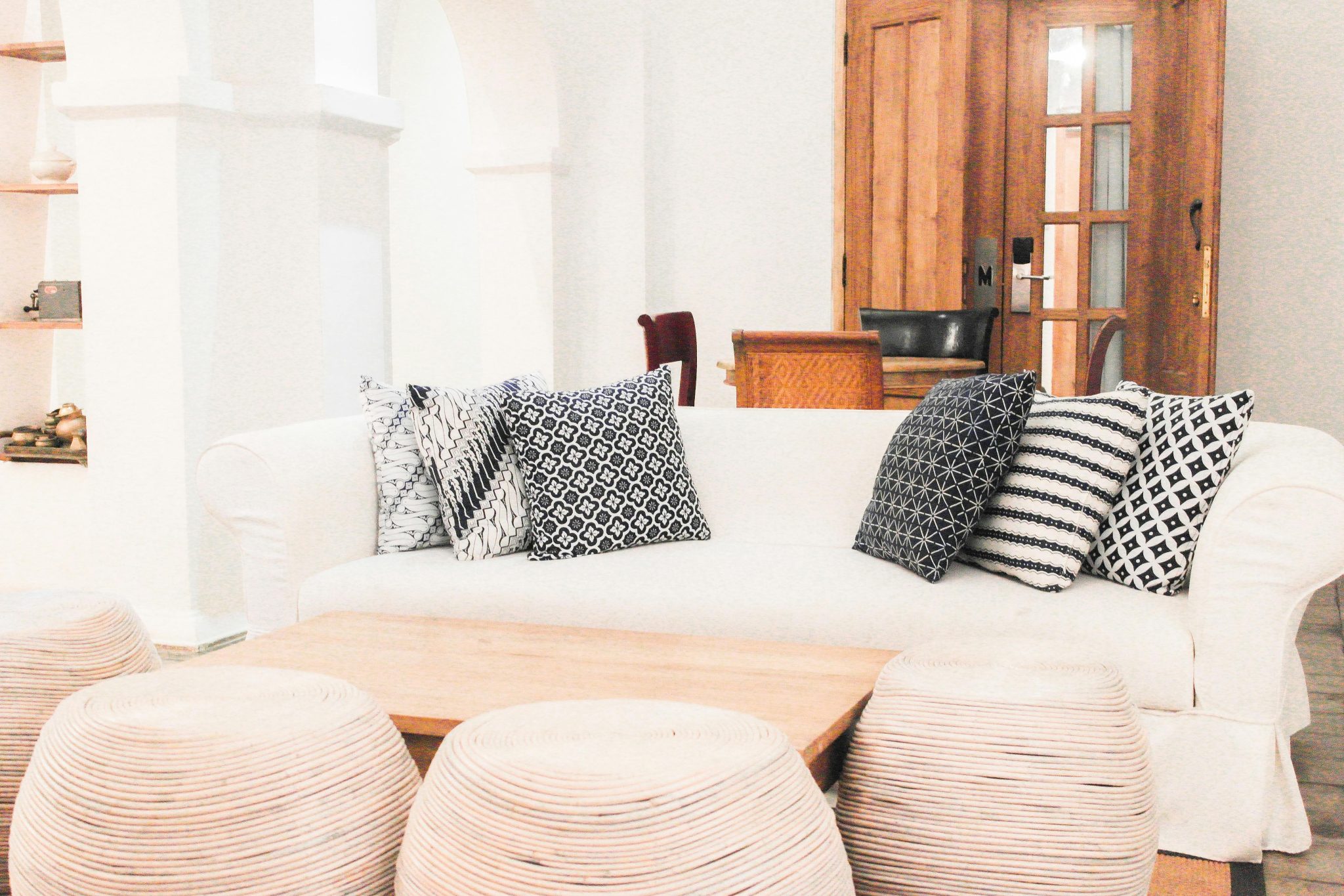 Stylish living room in Yogyakarta featuring a white sofa and patterned pillows, perfect for a modern home.