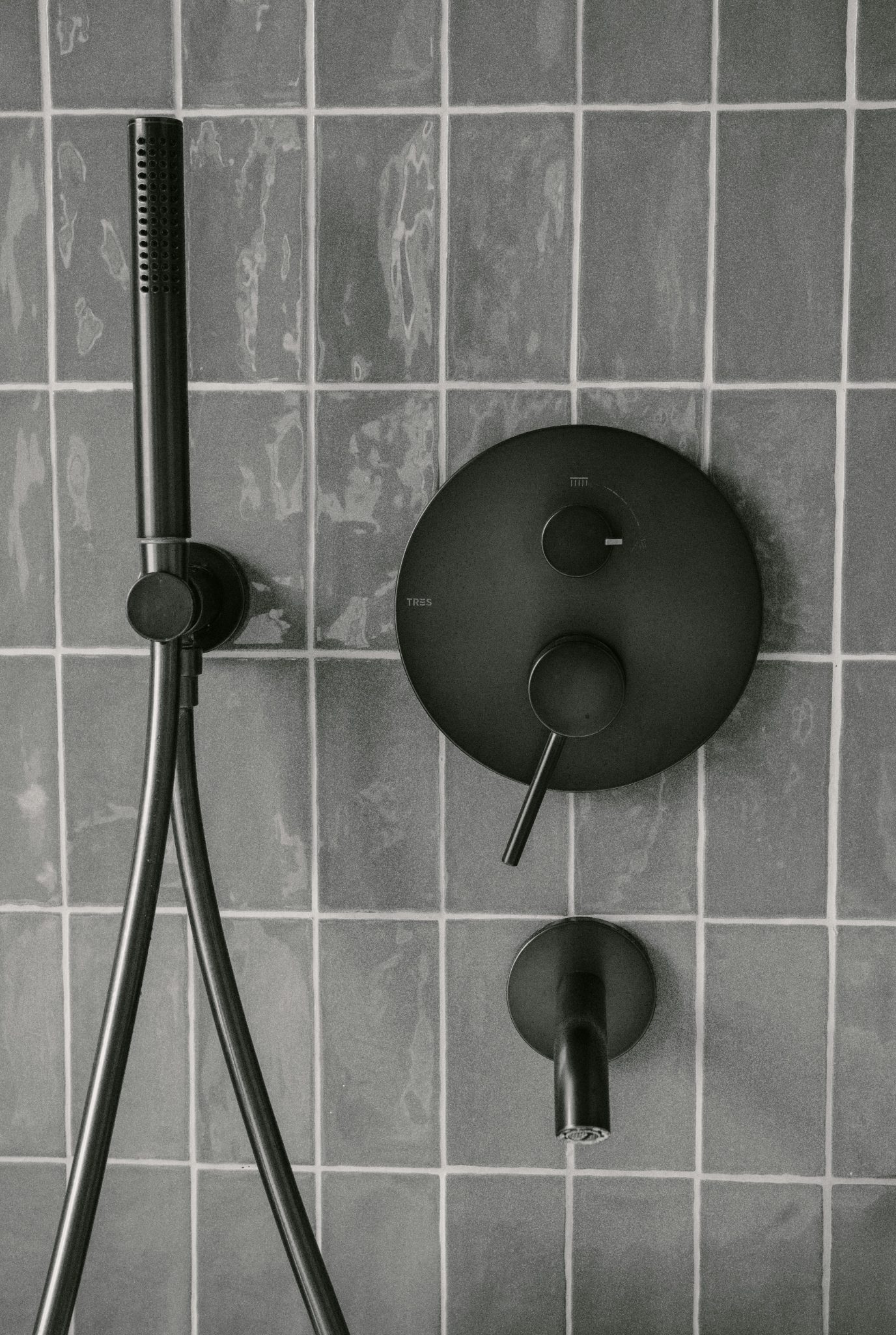 Stylish matte black shower fixtures on modern tiled wall, capturing minimalist bathroom design.