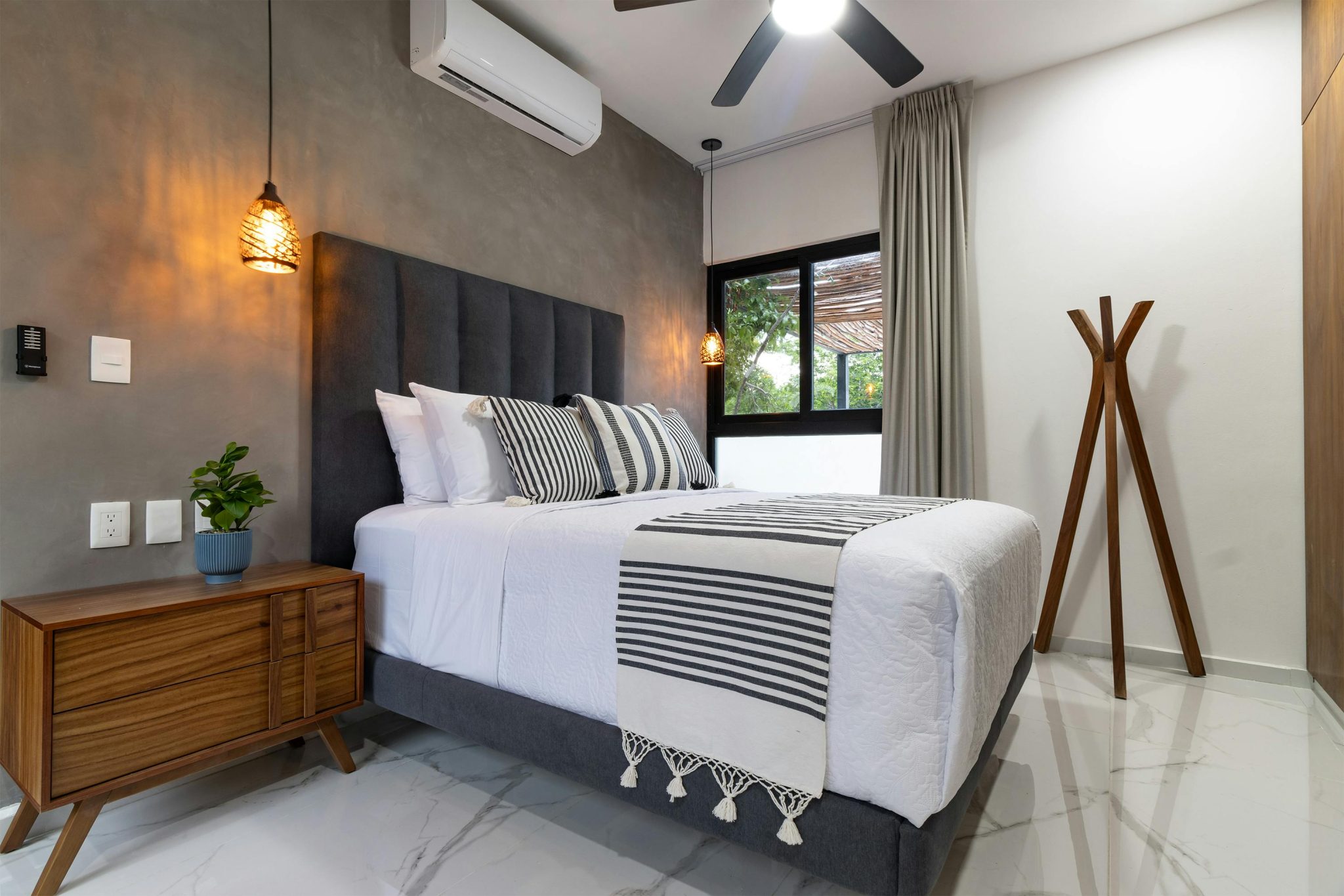 Stylish minimalist bedroom featuring a cozy bed, wooden accents, and modern decor.