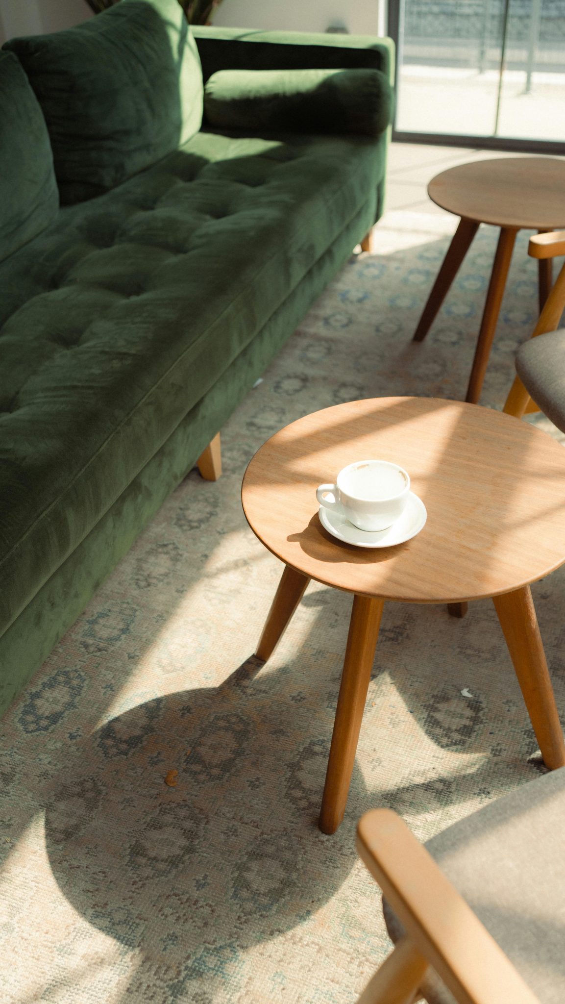 Sunlight streaming into a modern living room with green couch and wooden coffee table in Istanbul.