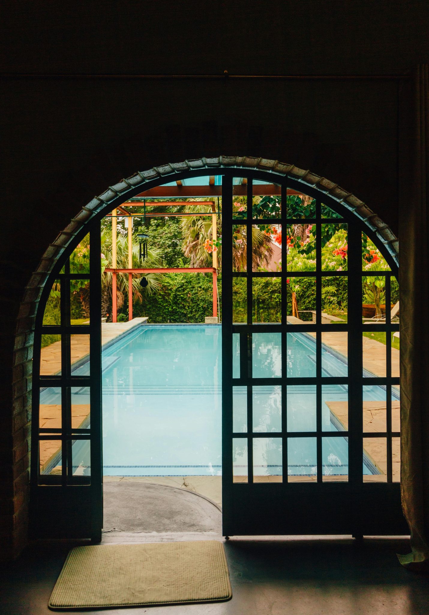 Tranquil pool seen through arched doors, perfect for relaxation.