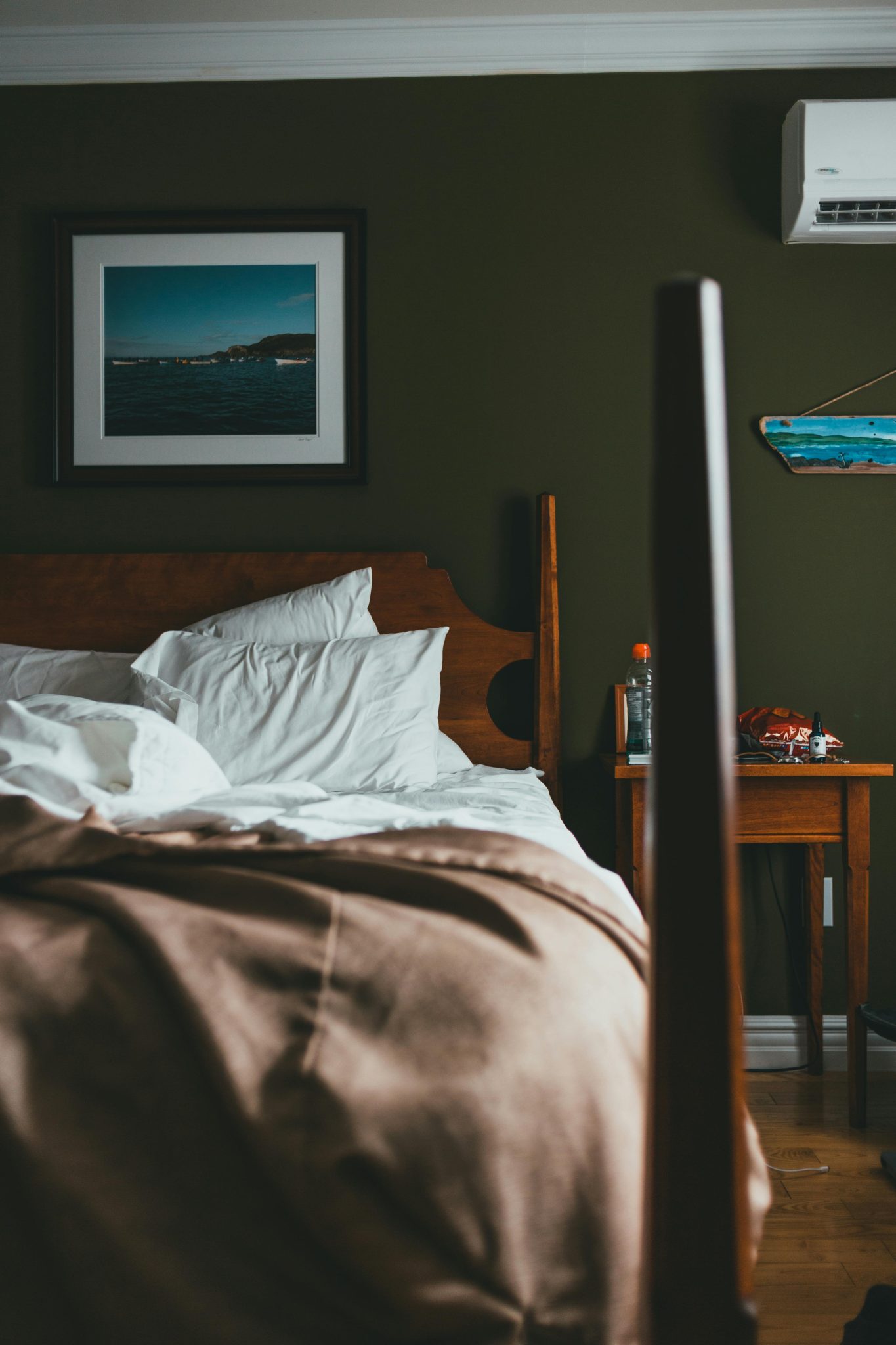Warm and inviting bedroom interior featuring a wooden bed and wall art, captured with Canon EOS 6D.