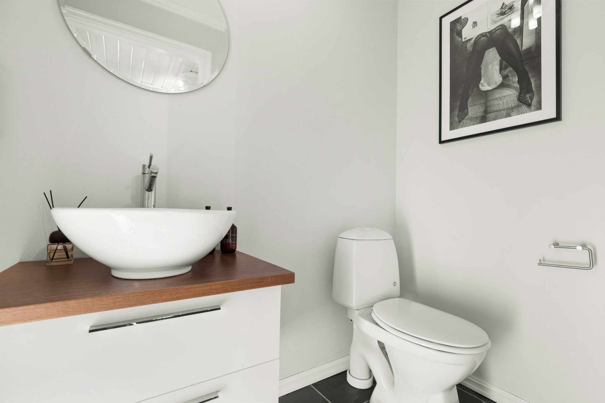 A bathroom with a sink, toilet and mirror