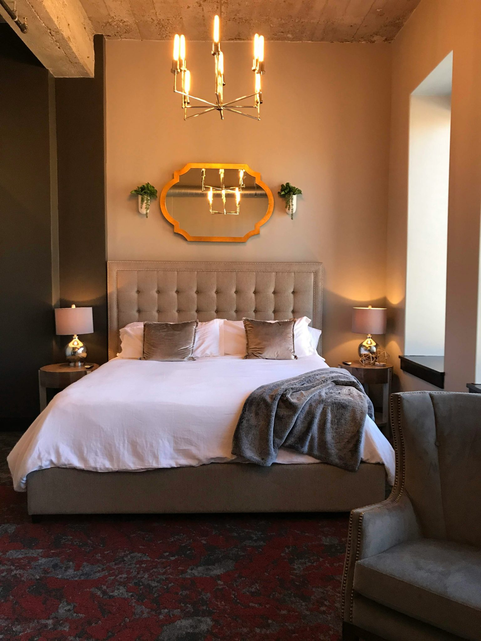 a bedroom with a large bed and a chandelier