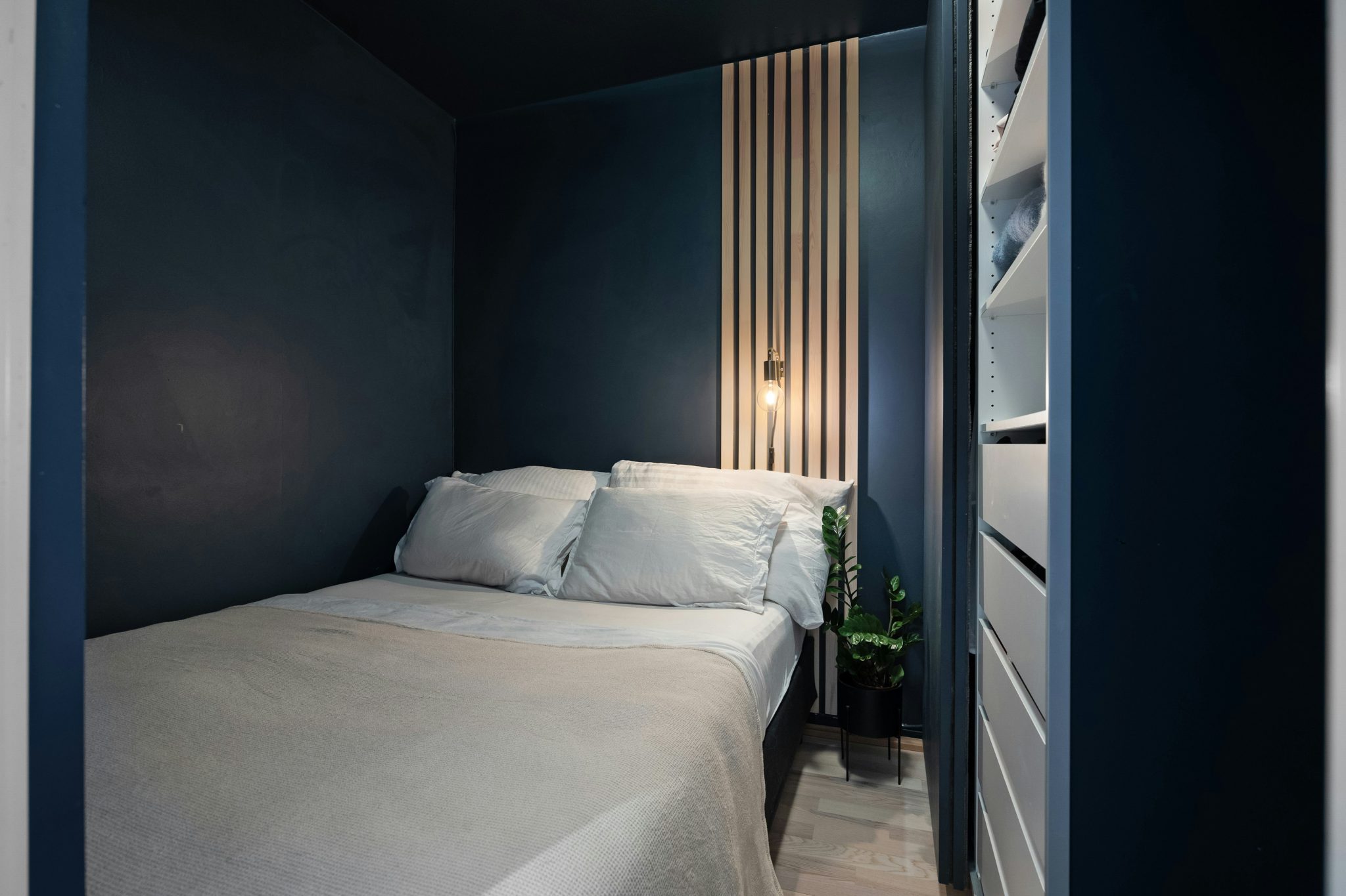 A bedroom with a white bed and blue walls