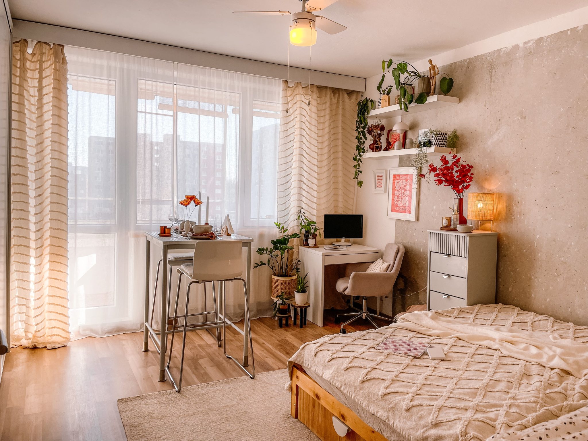 A bright and cozy Scandinavian-style bedroom with wooden floors, plants, and modern furnishings.
