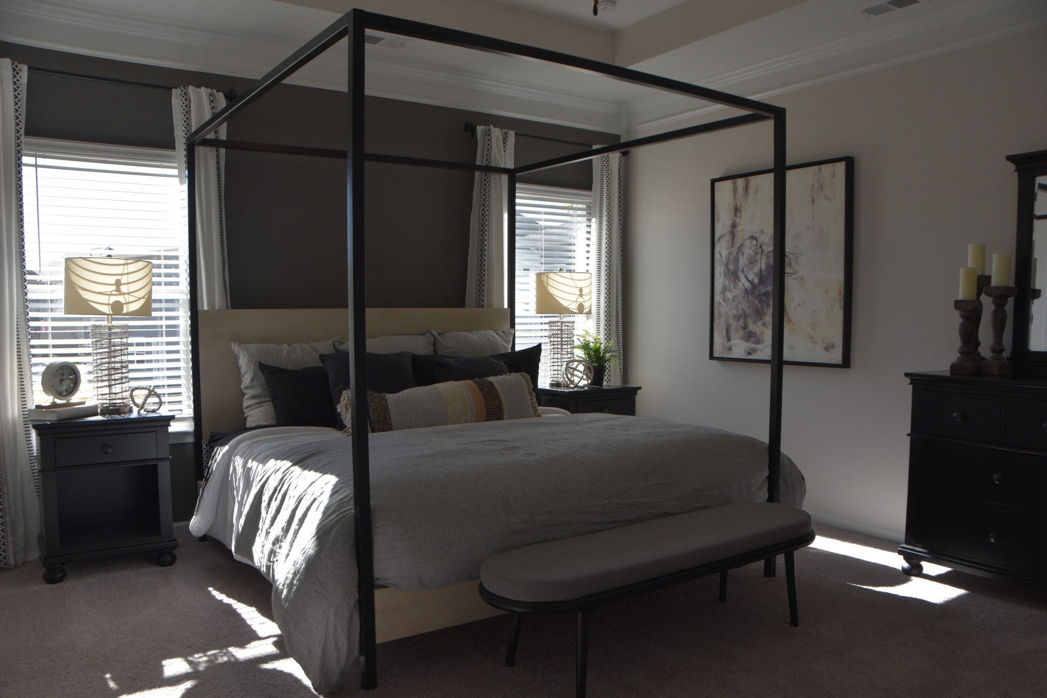 A chic bedroom featuring a stylish modern canopy bed, elegant decor, and natural lighting.