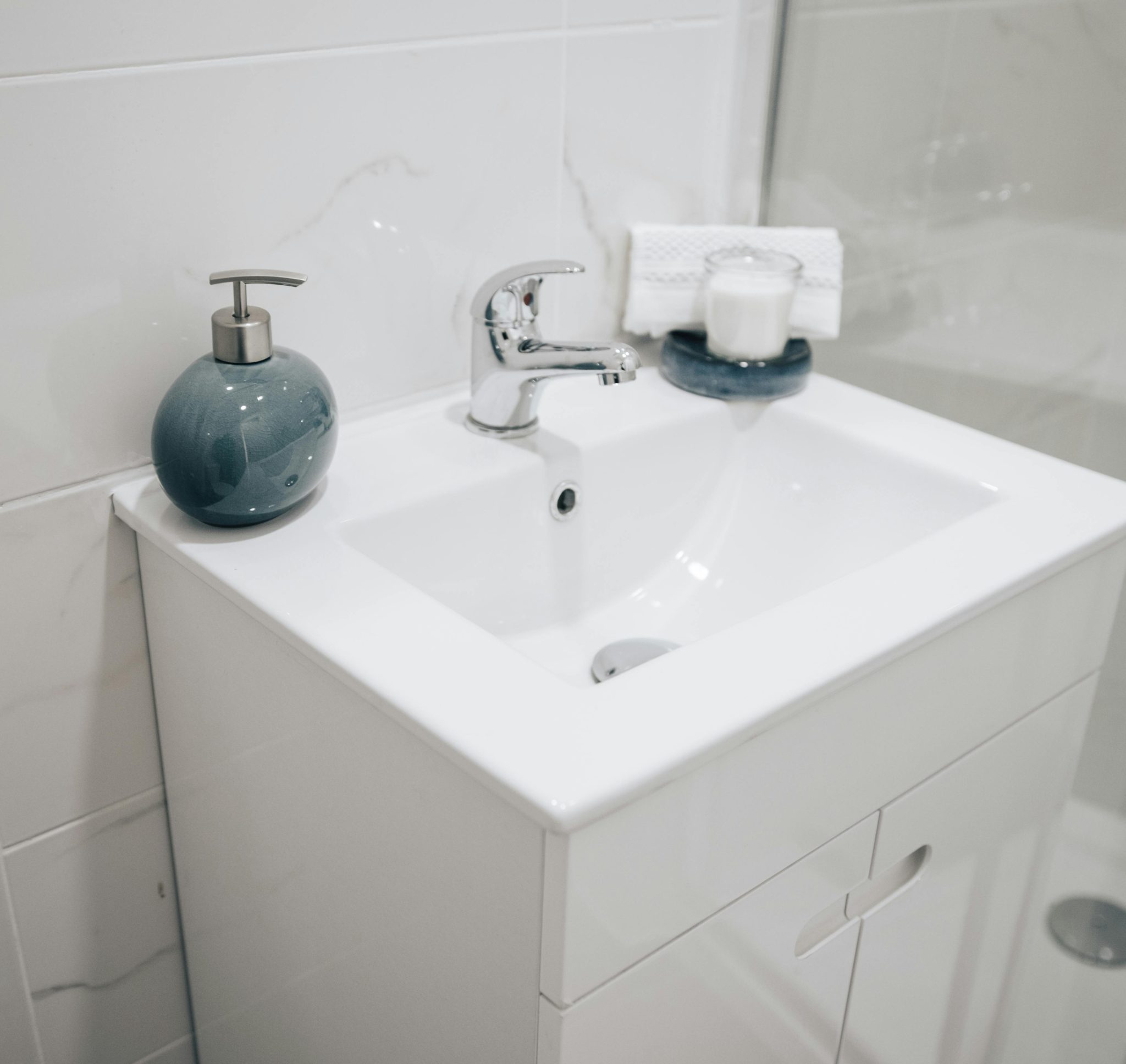 A clean and modern bathroom sink with a chrome faucet, soap dispenser, and towel for a fresh look.