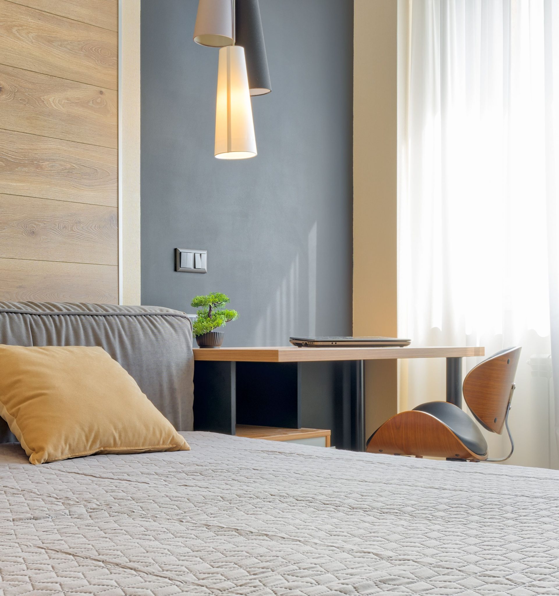A contemporary bedroom setup featuring pendant lights and minimalist decor.