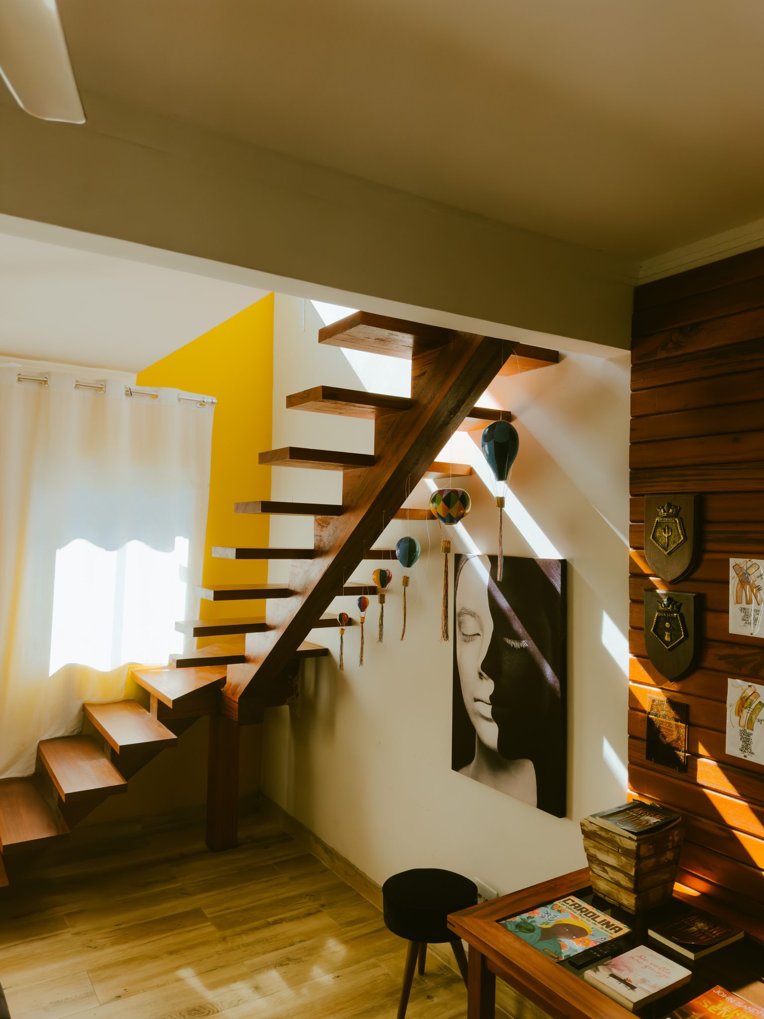 A contemporary wooden staircase in a sunny, stylish interior space.