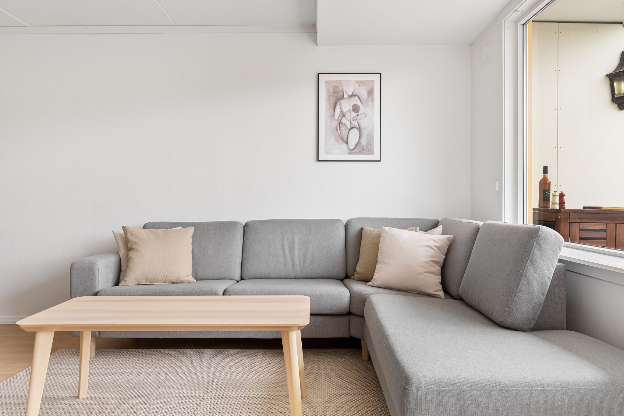 A cozy and modern living room featuring a grey sofa and wooden coffee table.