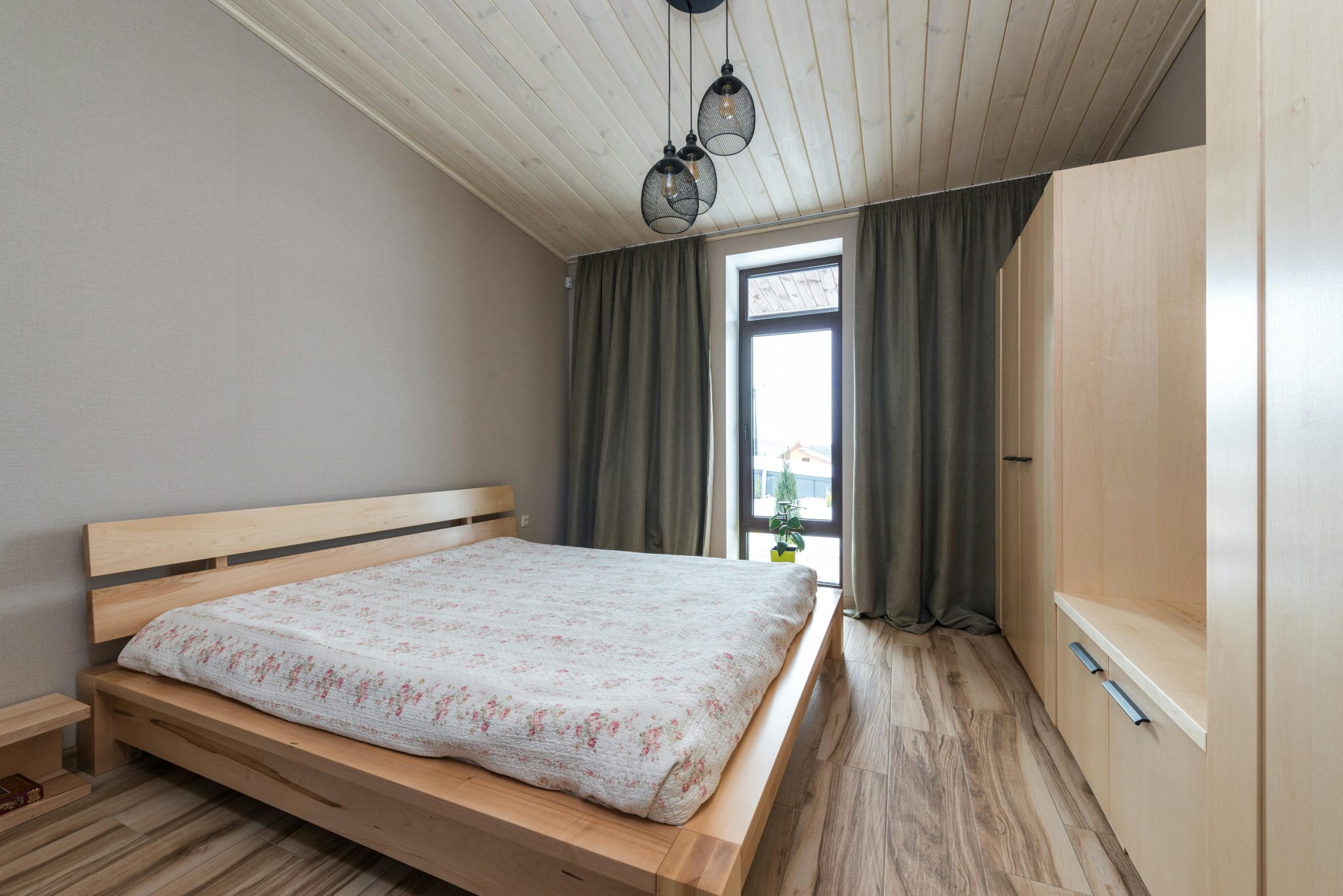 A cozy modern bedroom with wooden furniture and natural light.