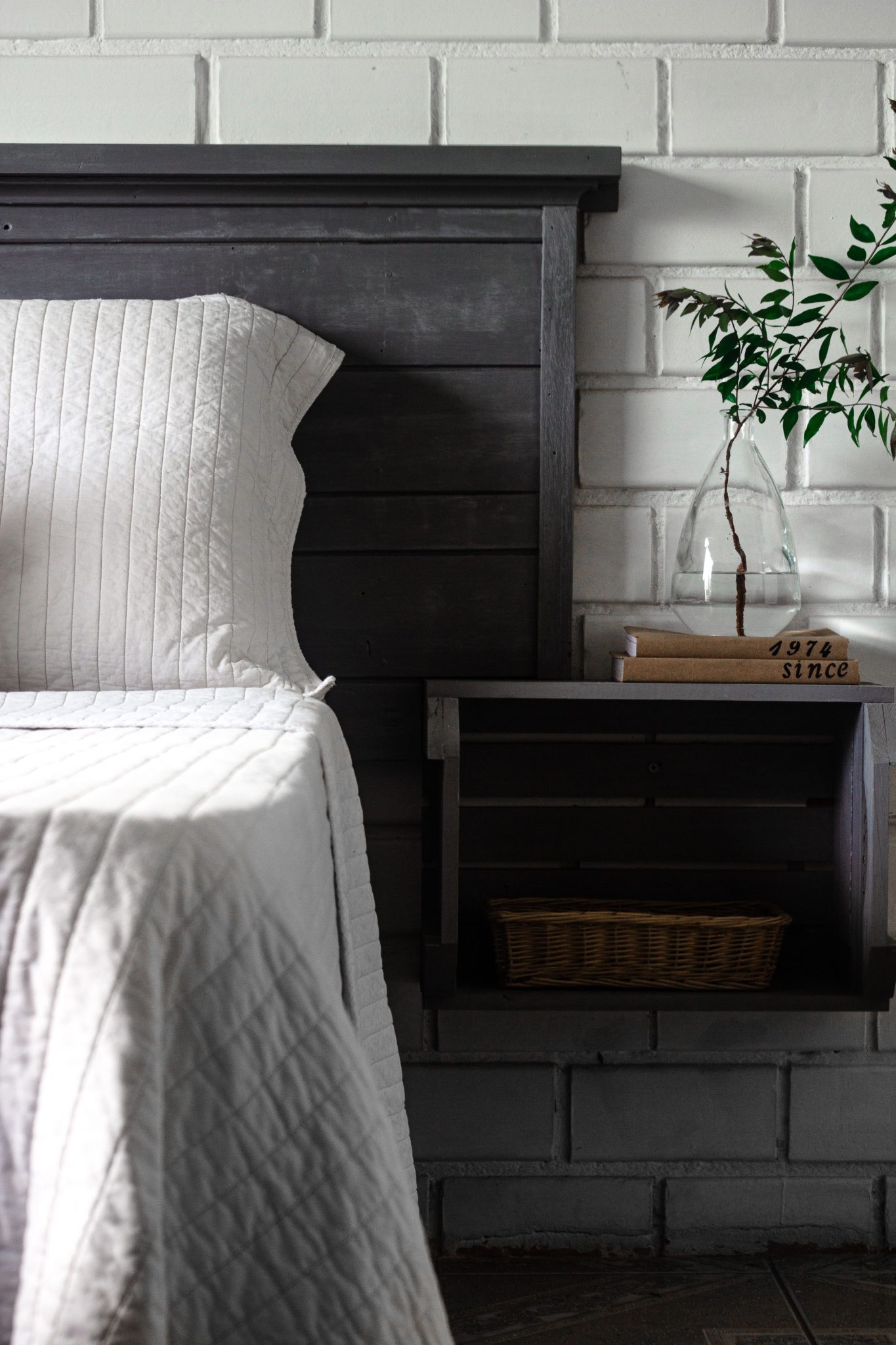 A minimalist bedroom with a floating bedside table and decorative elements.