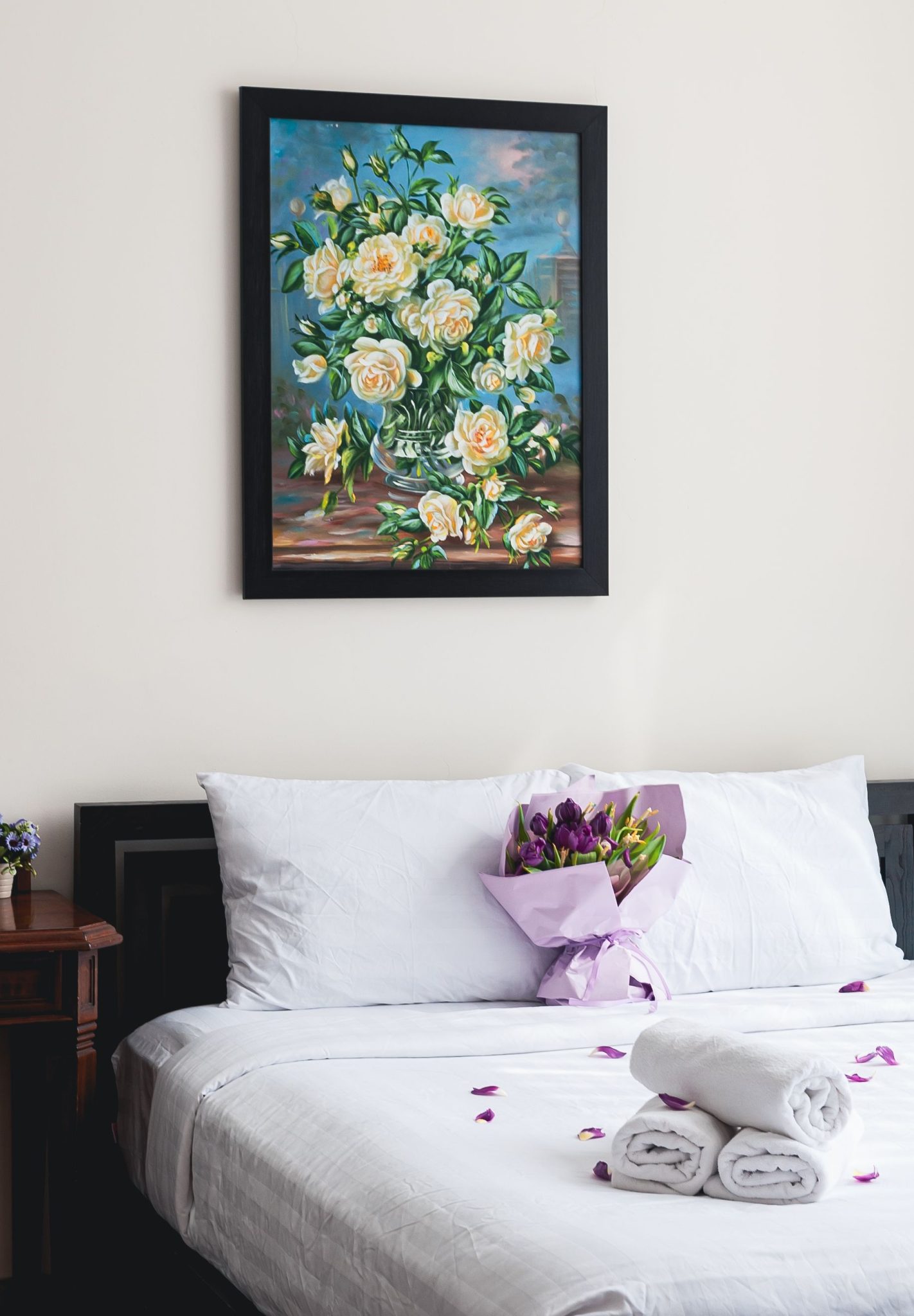 A serene bedroom with a vibrant floral painting and delicate bouquets, offering a luxurious and tranquil ambiance.