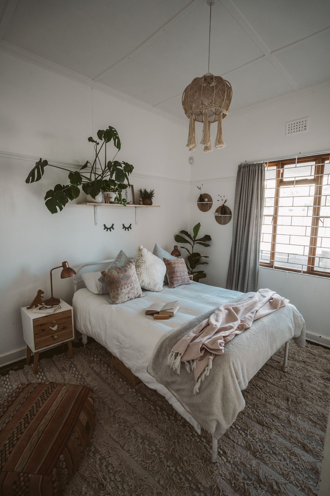A serene bedroom with natural decor elements, soft lighting, and indoor plants.