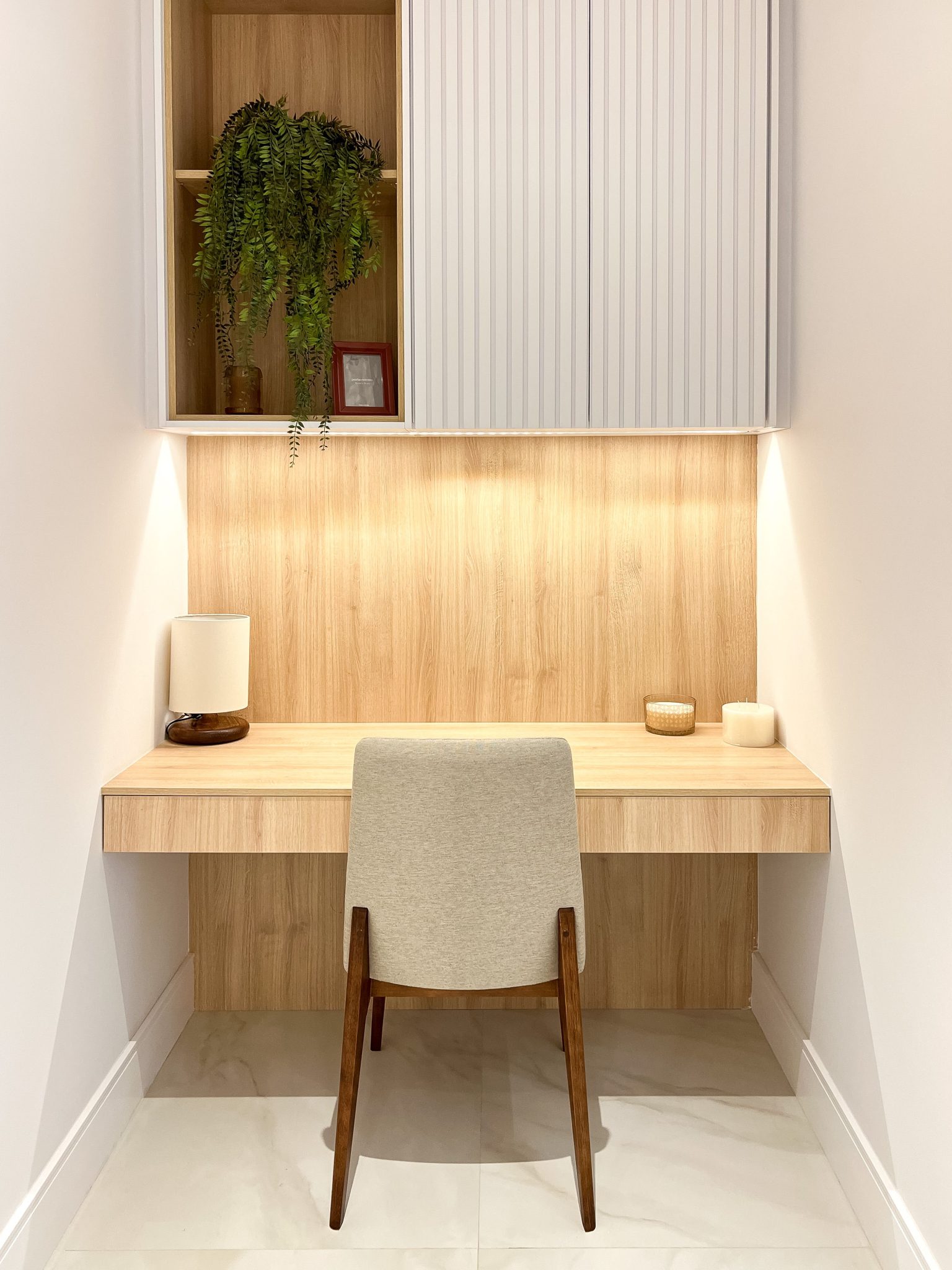 A stylish and minimalist home office space with wooden desk, chair, and decor.
