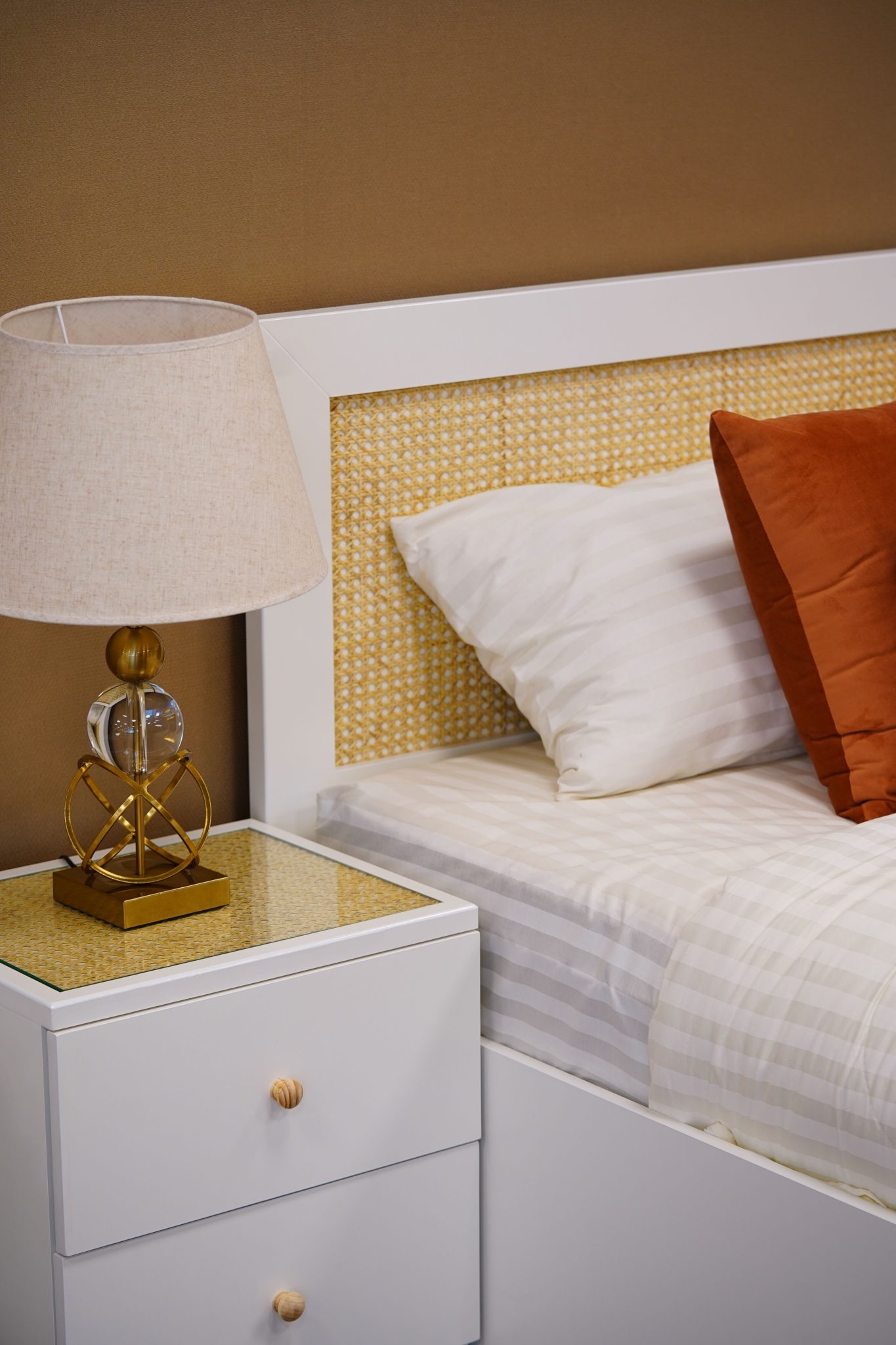 A stylish bedroom featuring a modern side table lamp and warm, inviting lighting.