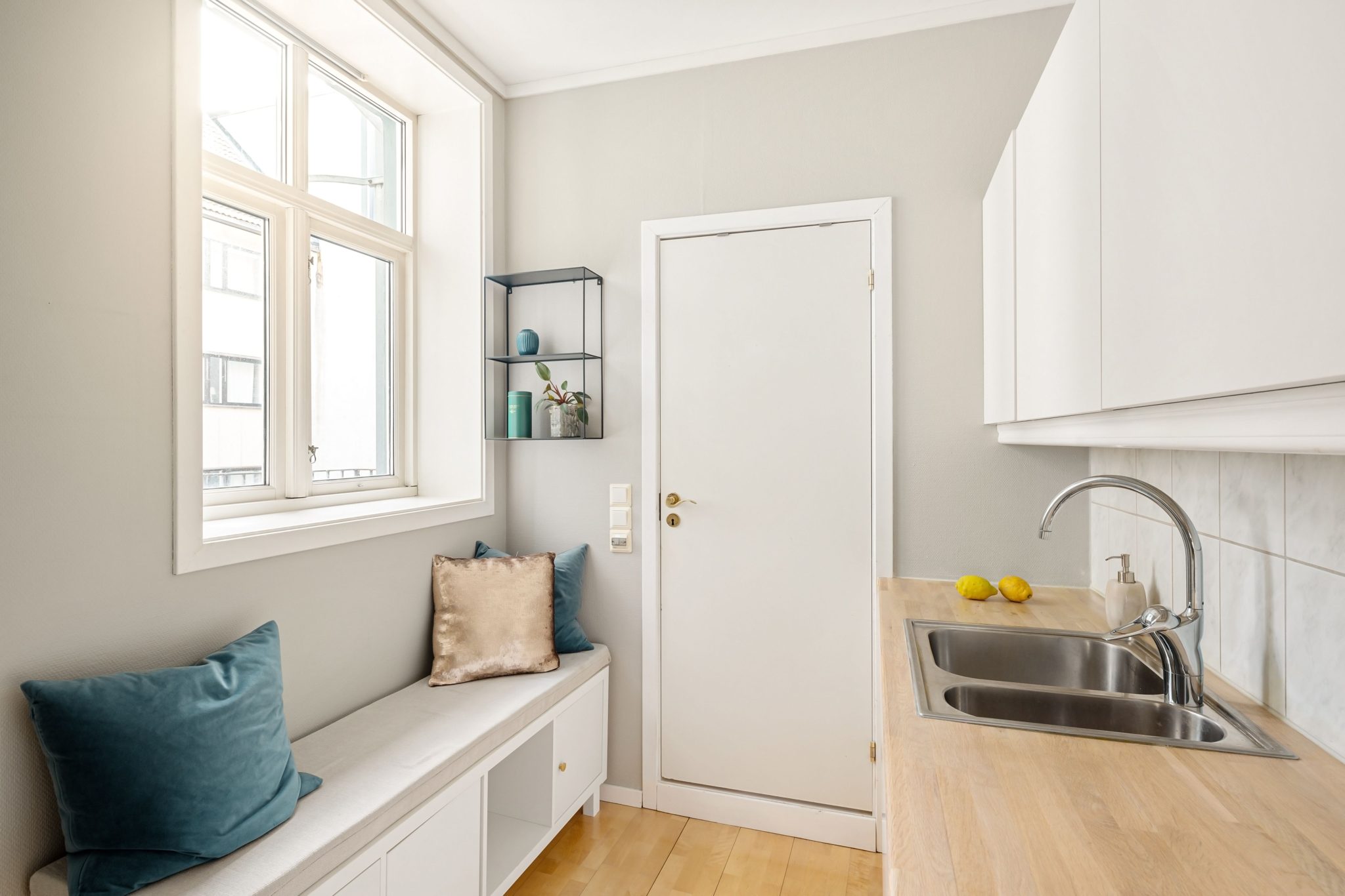 Bright and clean kitchen with white cabinets and wooden countertops, featuring cozy seating.