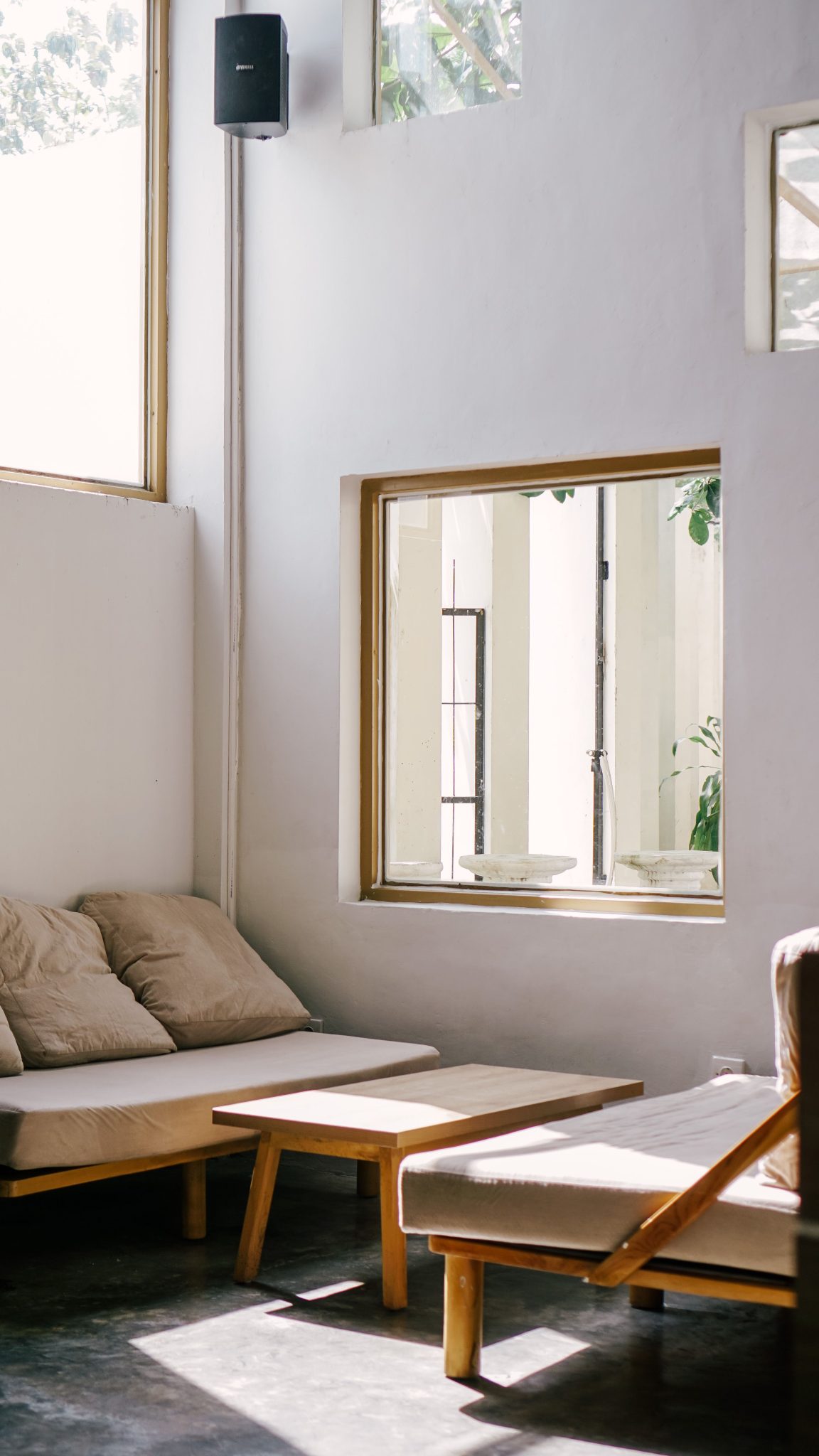Bright and modern living room featuring minimalist furniture and natural sunlight.