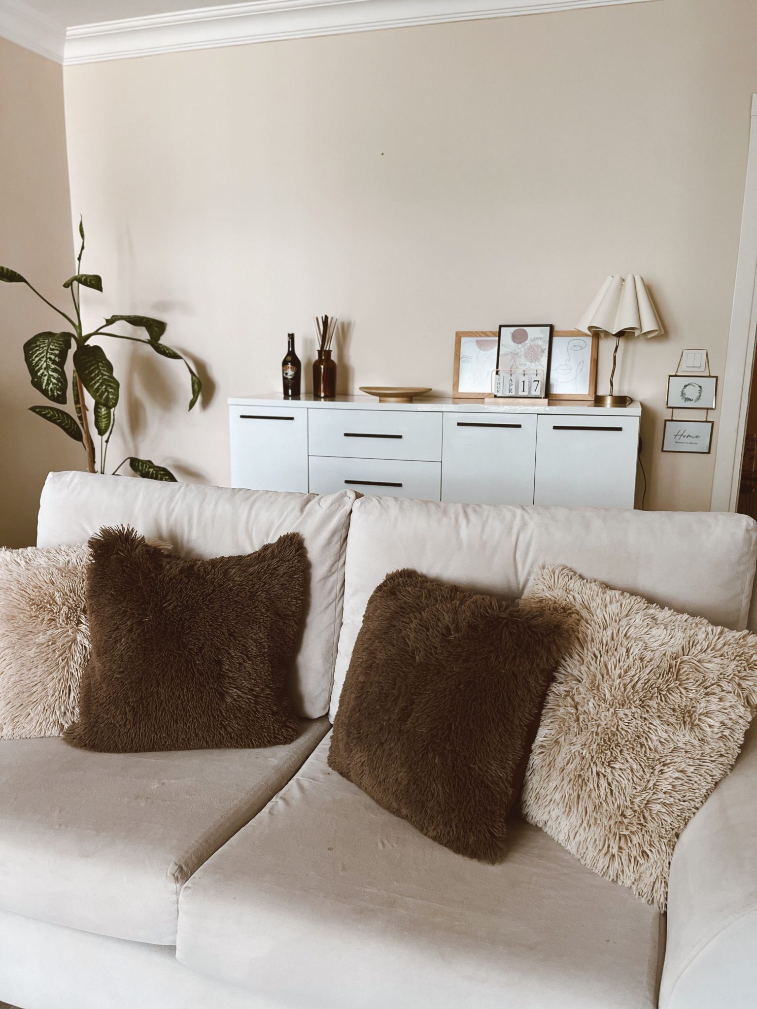 Comfortable beige sofa with fluffy pillows in a modern living room.