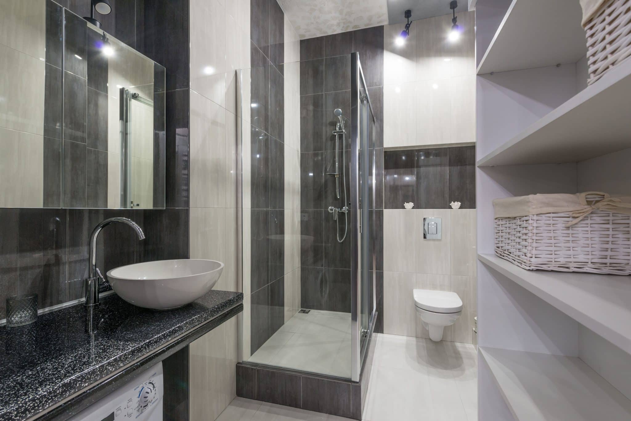 Contemporary bathroom design featuring glass shower, stylish sink, and storage shelving.