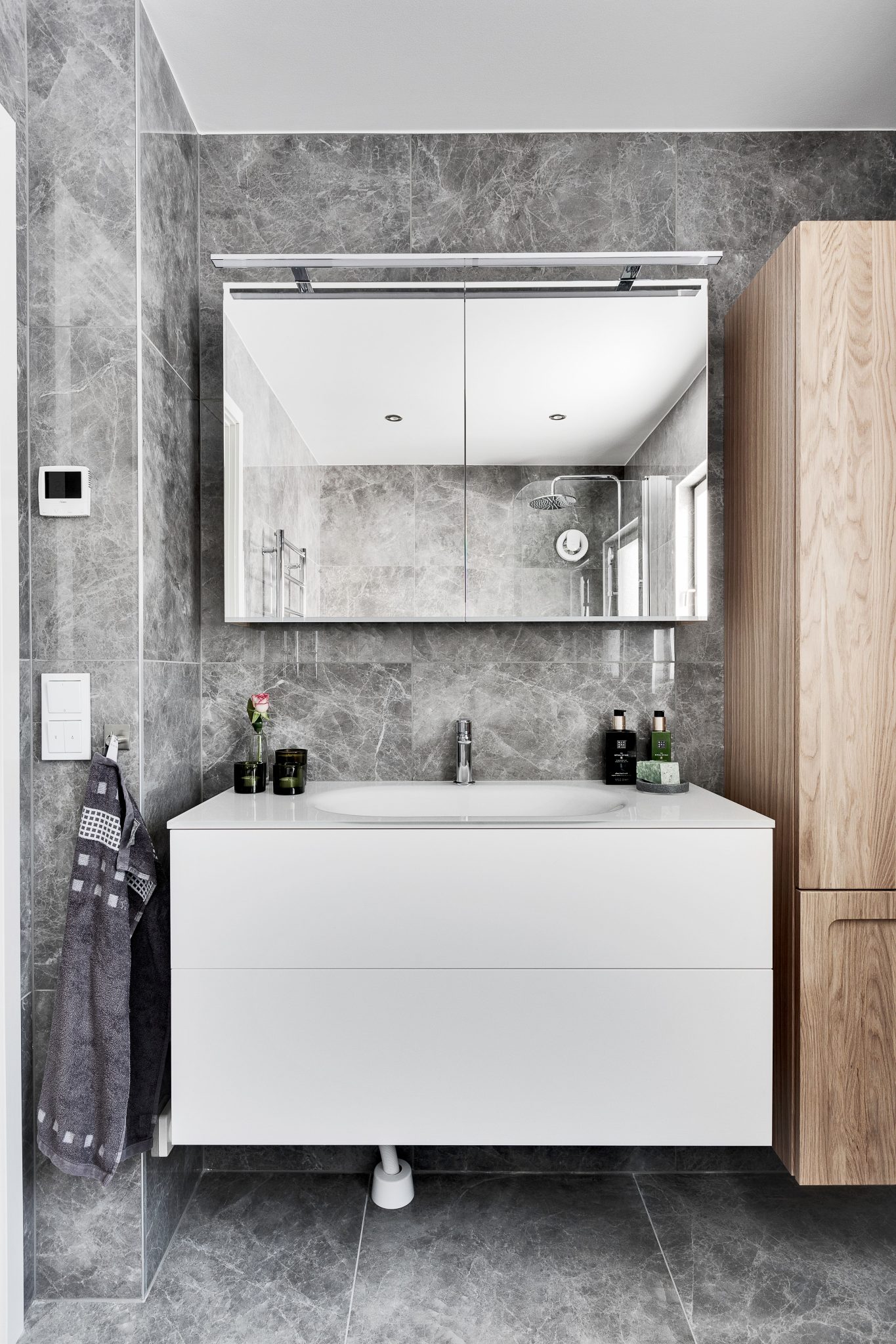 Contemporary bathroom with minimalist design featuring marble walls and sleek furniture.