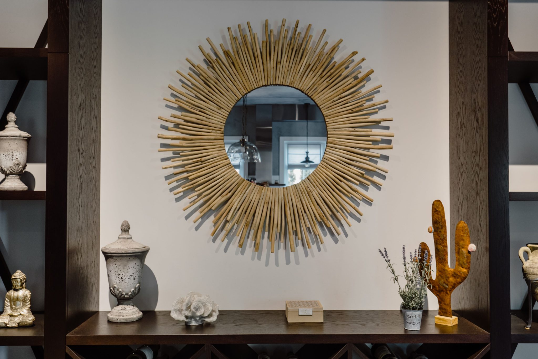 Contemporary living room featuring a unique sunburst mirror and chic decor accents.