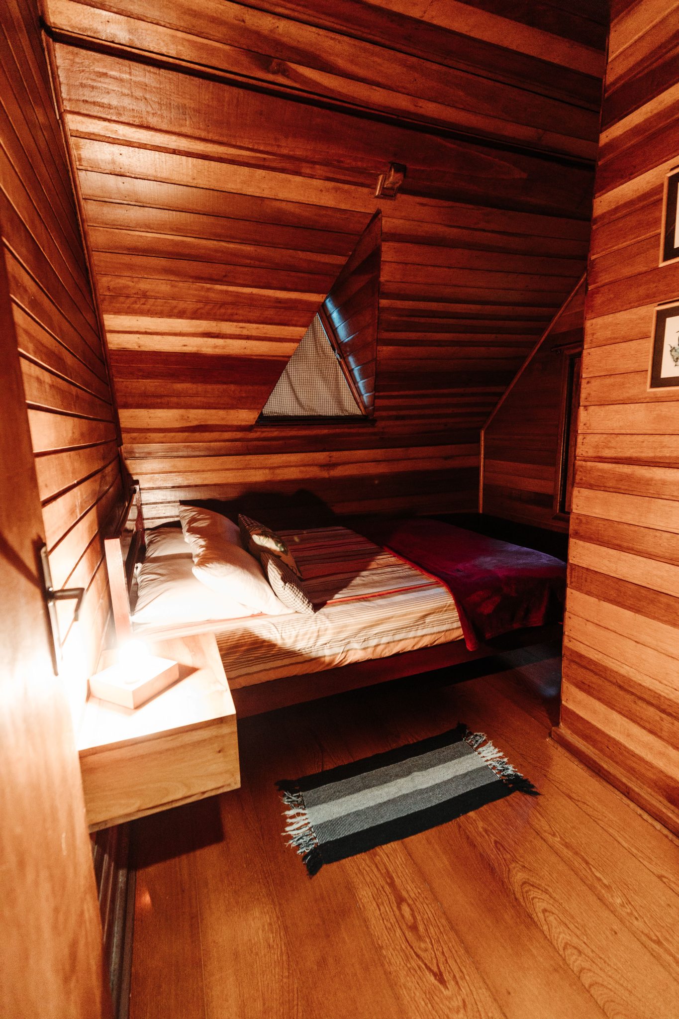 Cozy wooden bedroom with ambient lighting in a cabin-style room