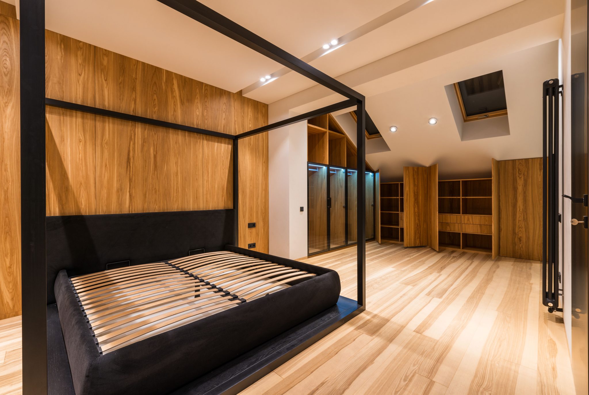 Interior of comfortable room with wooden cabinets and soft bed in mansard of cottage